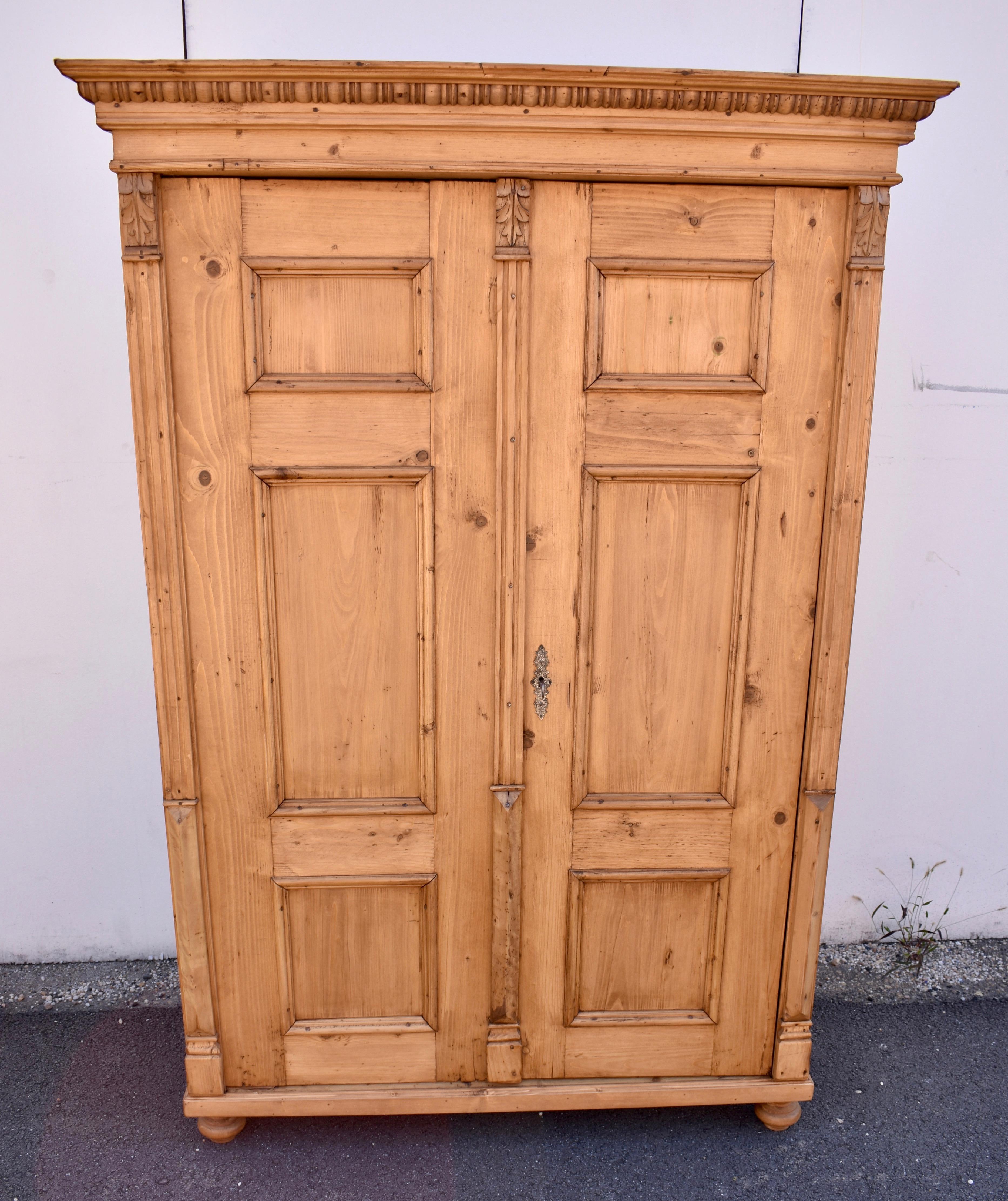This is an attractive two door armoire with only very small knots and a nice even honey color, hand-polished to a lovely sheen.  Several tiers of molding, including a strip of quarter round gadroon, make up the impressive crown.  The doors each have