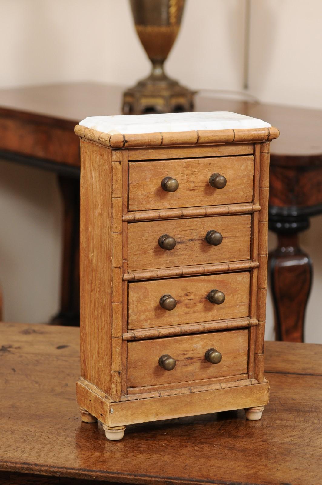 This petite chest would work well as a jewelry box or or for cufflinks or other small accessories storage. Featuring pine carved in a bamboo style, brass knobs and a marble top, this piece originates from England, ca. 1900. Truly charming.