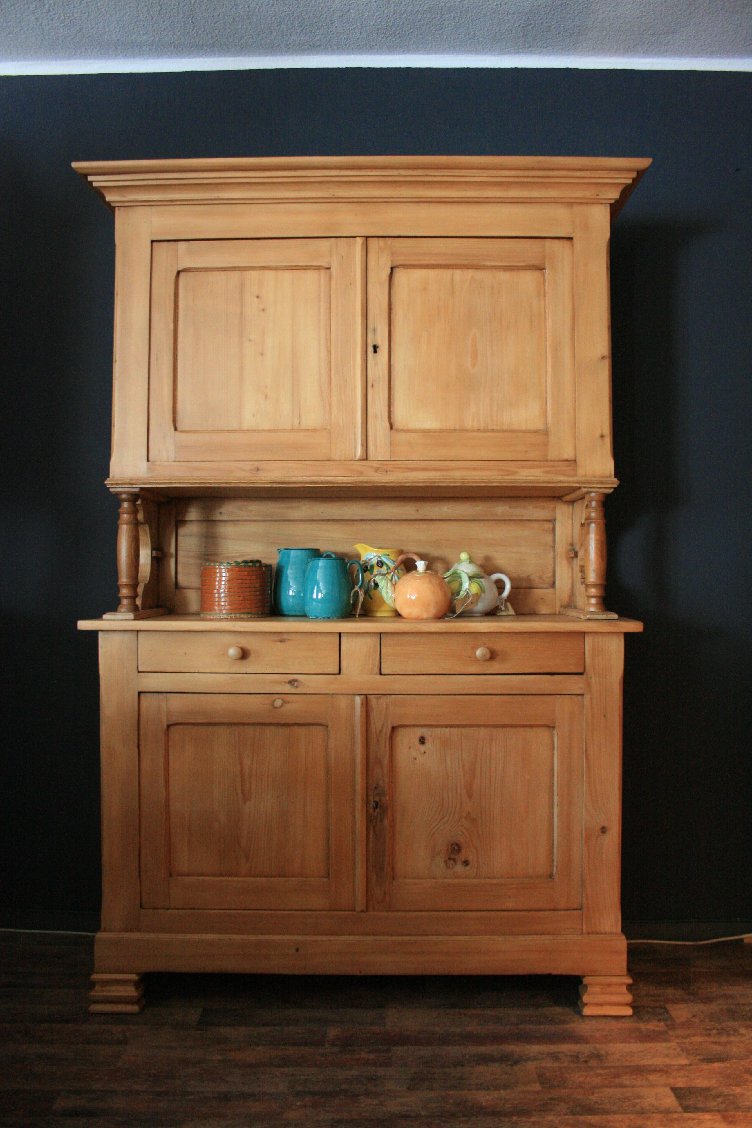 Large antique kitchen buffet made of pine, circa 1880. Completely restored. Two-part with turned columns in the middle.
The cabinet provides plenty of storage space behind the doors in the top and bottom for e.g. Pans and pots, as well as for