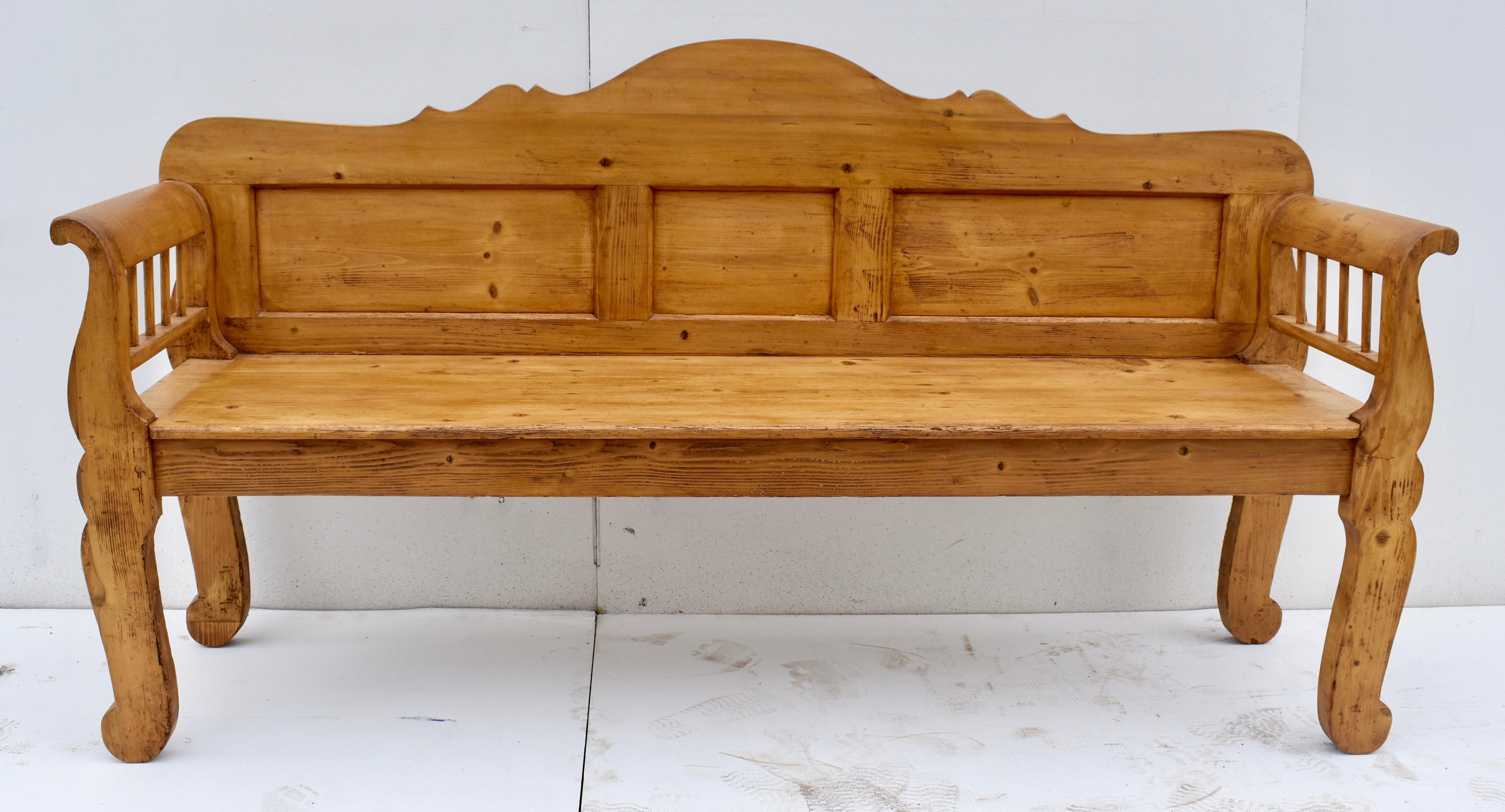 This fine bench is as sturdy as it is handsome. The scalloped top rail is beautifully proportioned and rests above three flat panels. The boldly scrolled arms enclose four spindles each side. Four stylized cabriole legs add to the presence of the