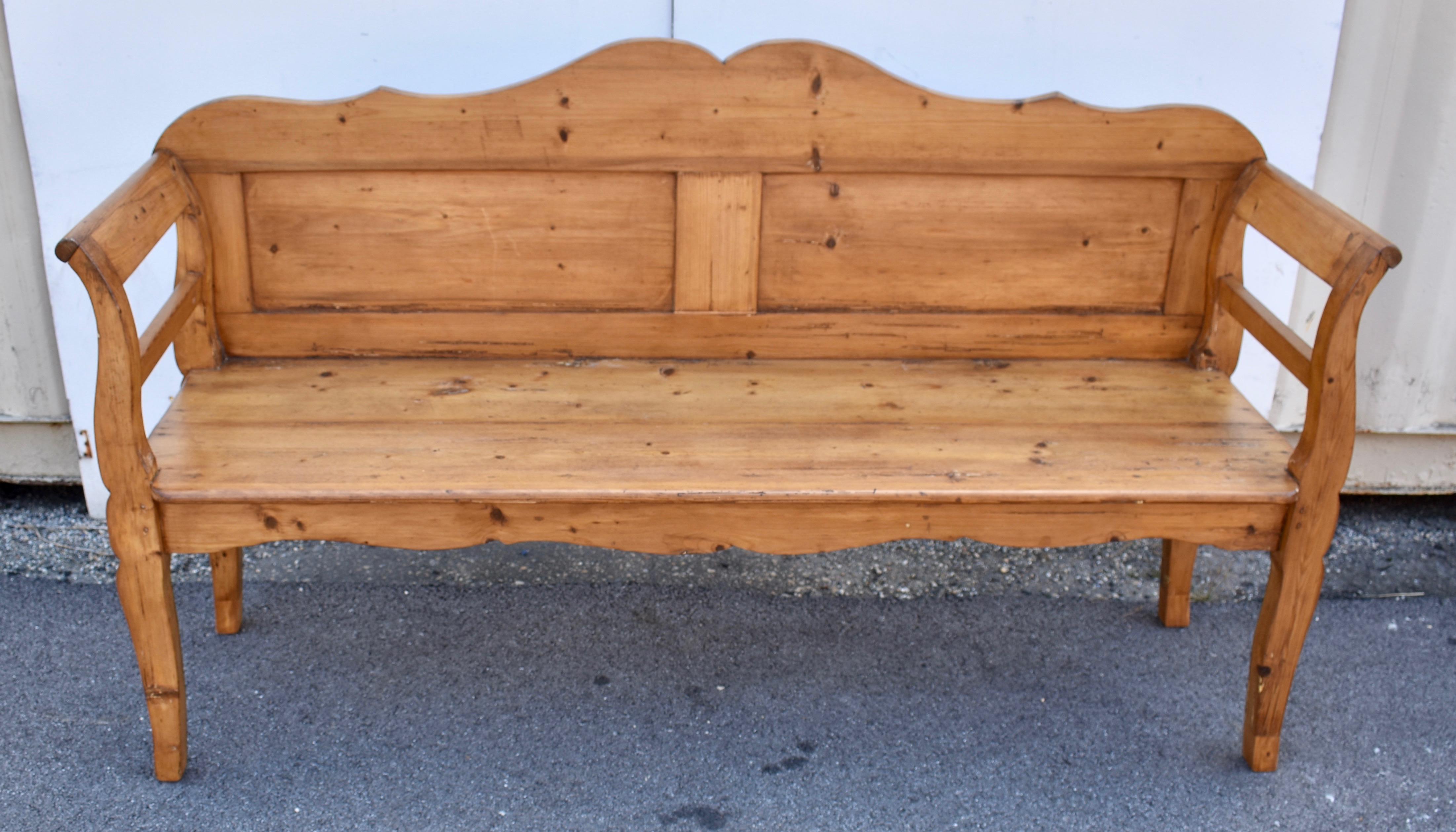 This is the classic shape for a Hungarian Bench or Settle.  The top rail is nicely scalloped and sits on top of two rectangular flat panels.  The integral arms and legs present a gentle cabriole at the leg and a bold curve and scroll at the arm. 