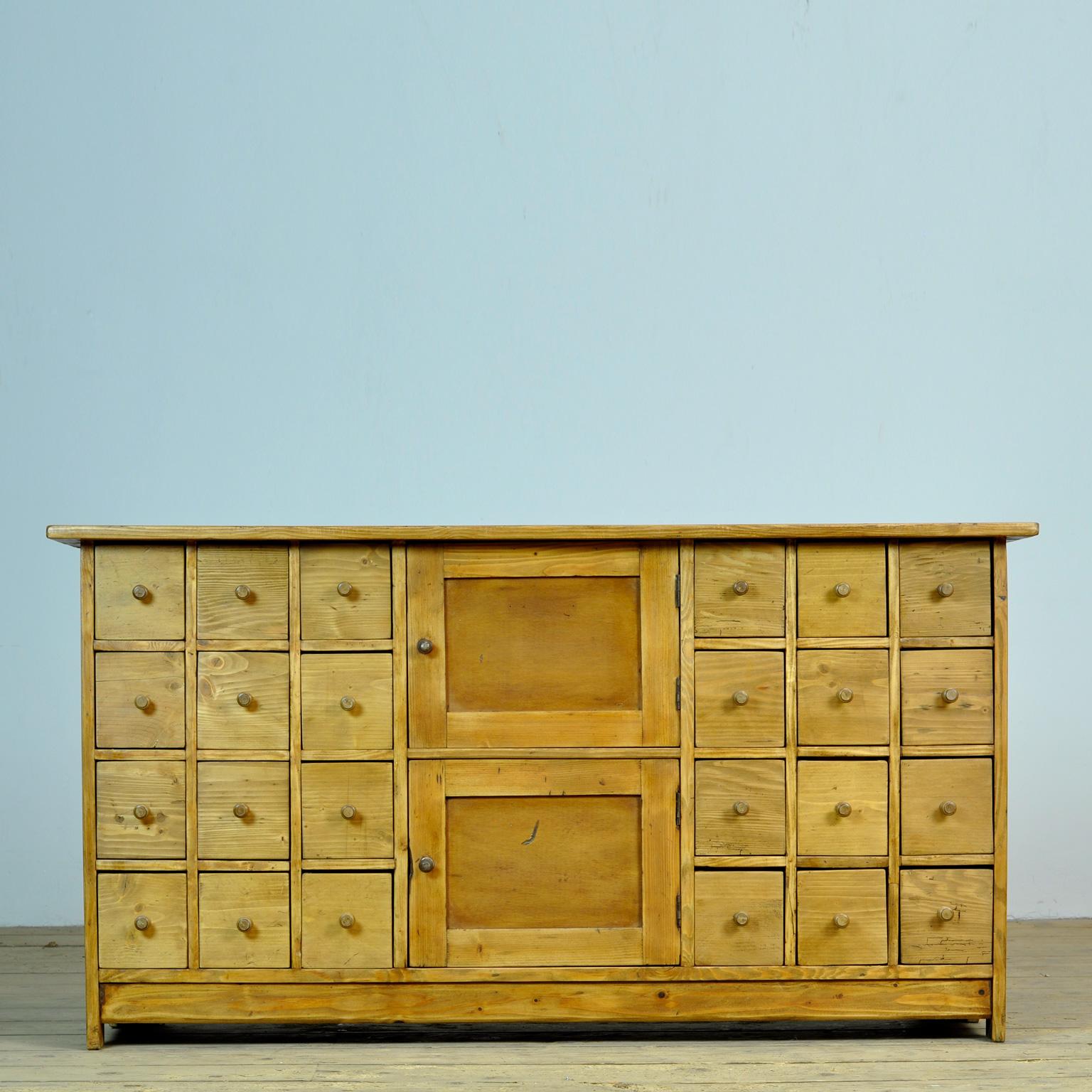 Pine chest of drawers from circa 1940. The chest has 24 drawers en 2 doors. Very nice piece for in the hallway!
Some of the drawers have been replaced as well as the wooden knobs.