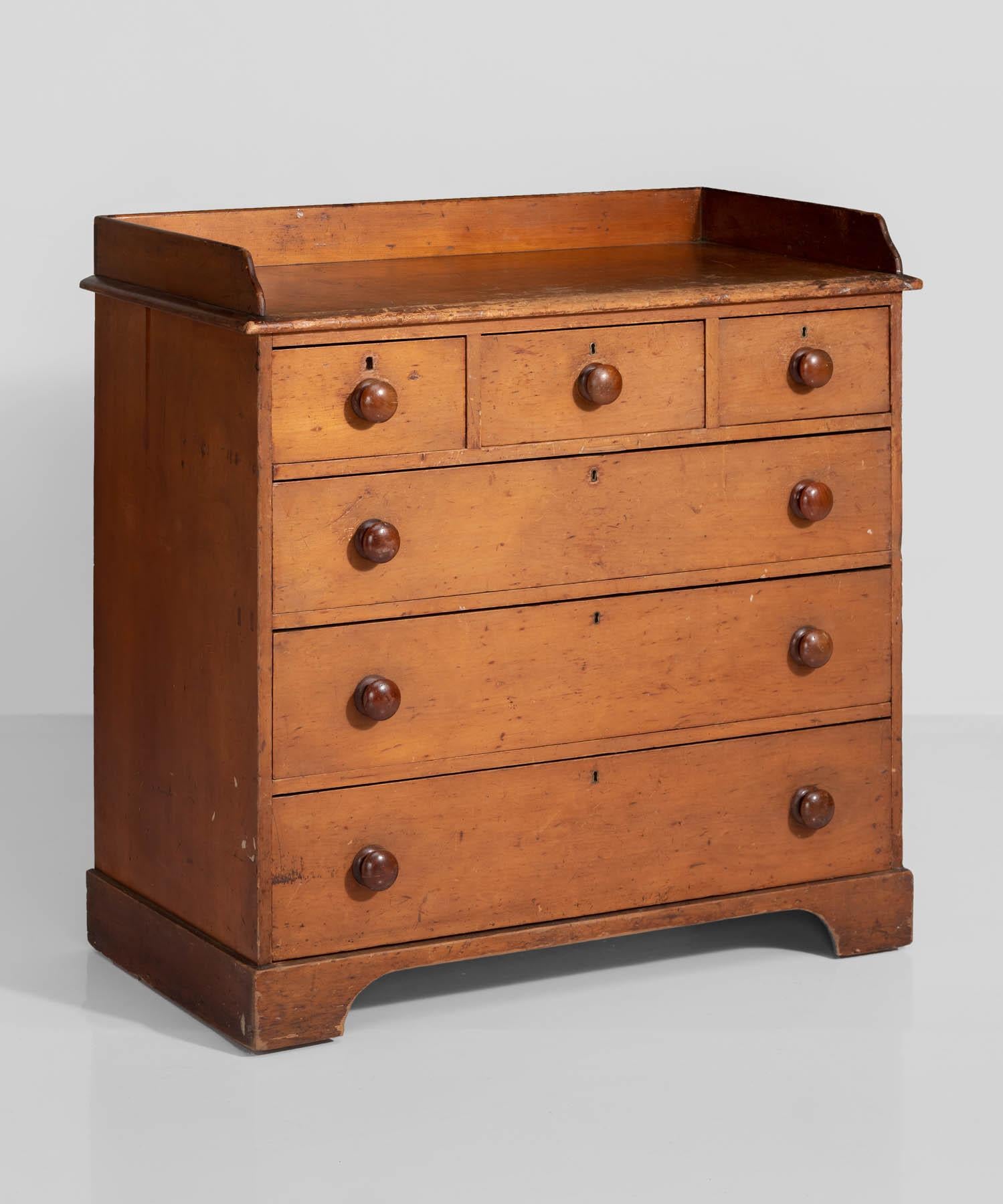 Pine chest of drawers, England, circa 1890.

Simple, minimal form with oversized circular pulls.

Measures: 42.5