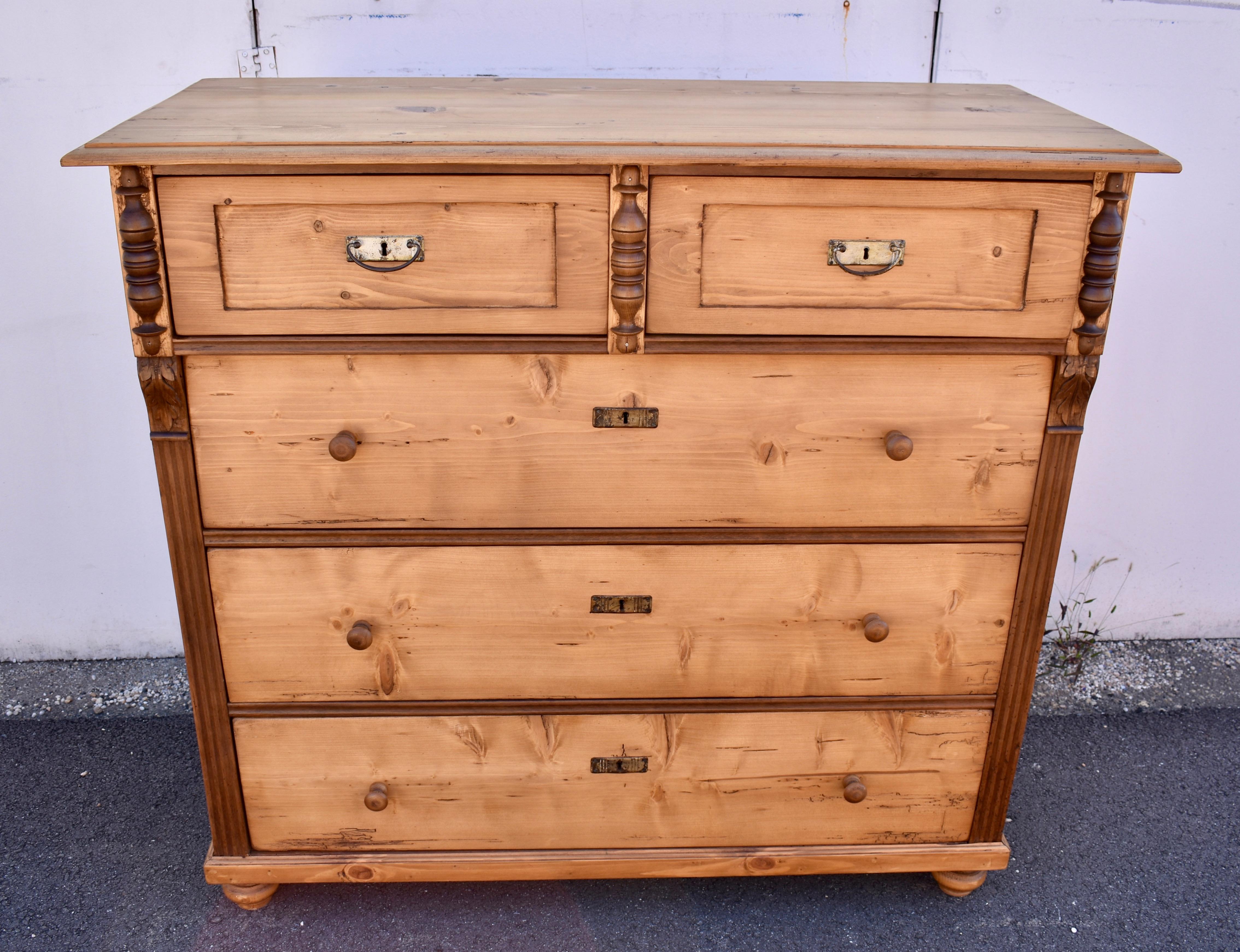 The breakfront case of this impressively large chest sets the two top drawers proud of the lower three.  Applied trim to the top drawers gives a faux paneled effect.  Between them is a hardwood split baluster, which repeats on the outside corners. 