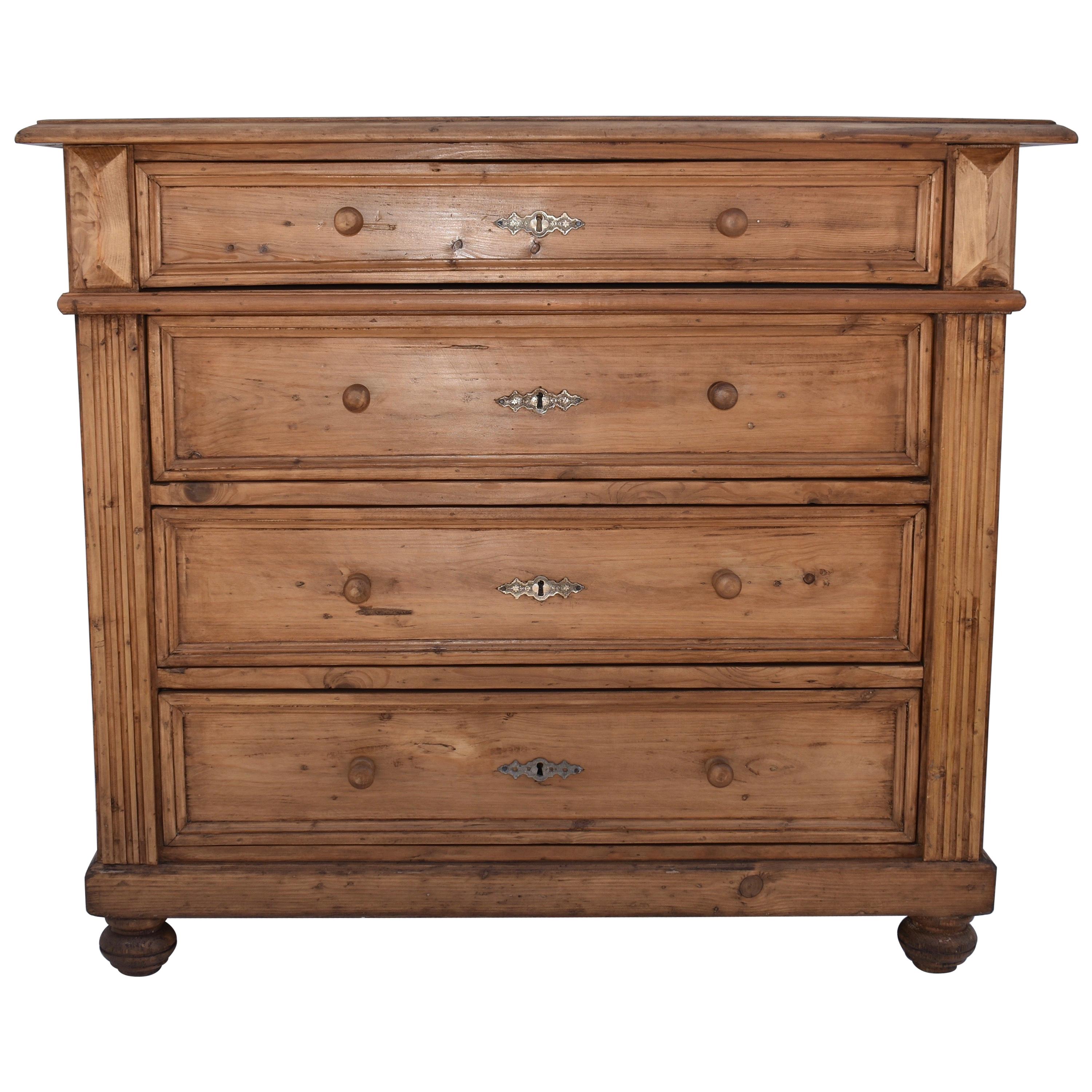 This handsome little pine chest of drawers has a step-down routed edge to the top and fluting to the front corners. The three lower drawers are equal with a shallow one on top, with a border of pine molding and zinc escutcheon plate. A great piece