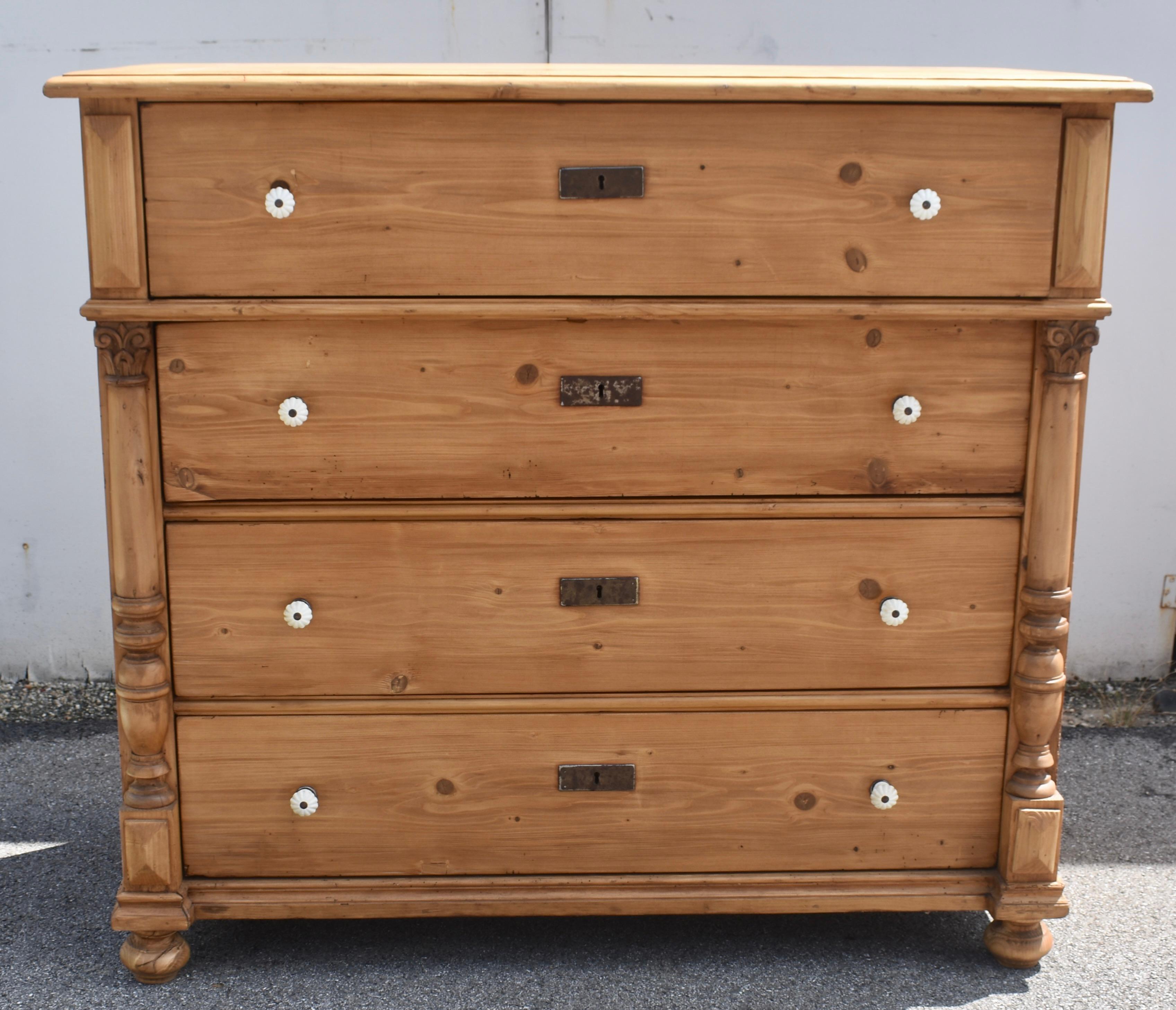 This large handsome chest of four equal depth hand-cut dovetailed drawers is perfectly proportioned.  The top has a shallow routed step down.  The top drawer stands slightly proud of the other three and is flanked by elongated pyramid appliques. 