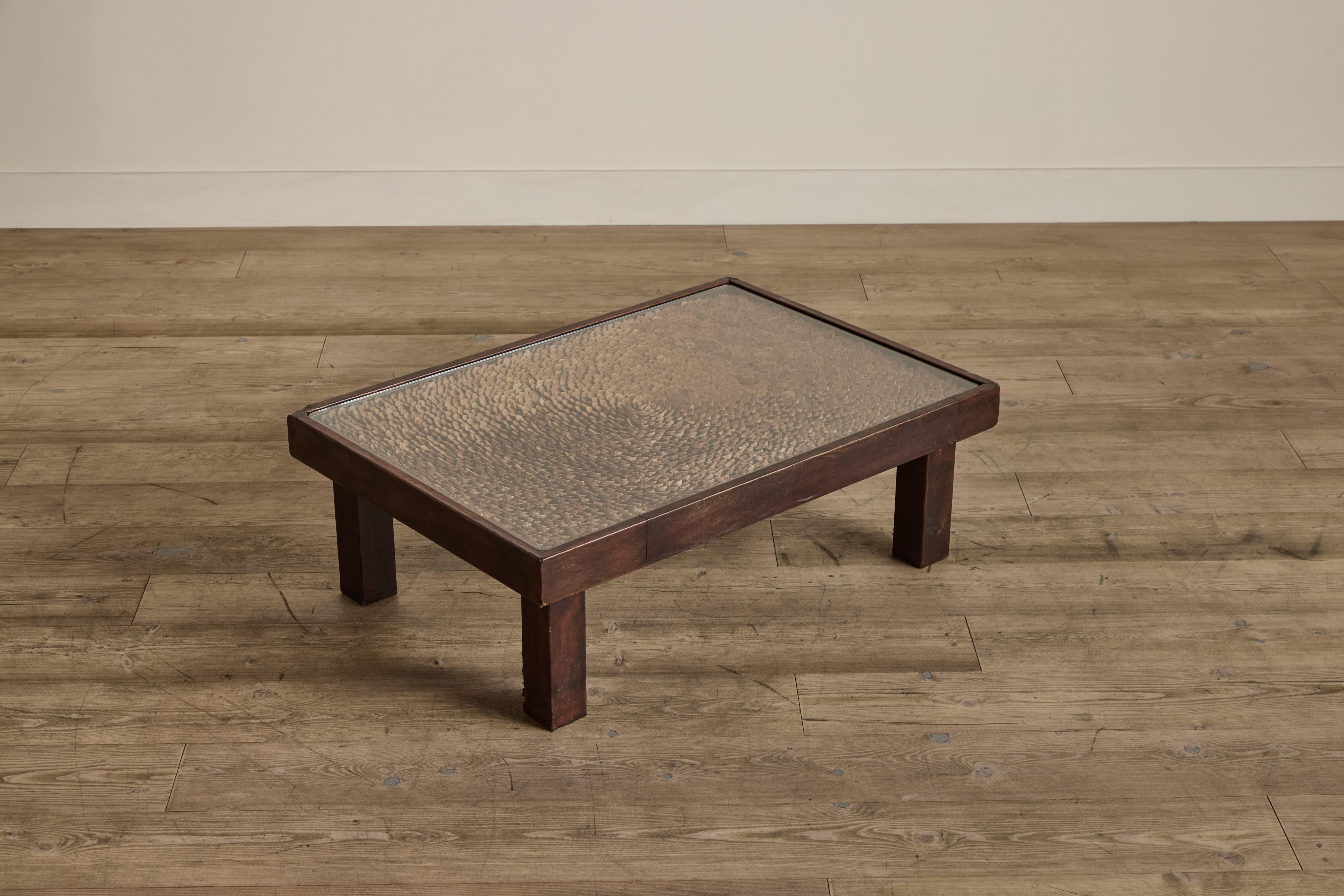 Pine cone coffee table from France circa 1960. Table base is wrapped in leather with a glass top. Under the glass top is a stunning pattern made of pieces of pine cones. Table is in good condition with some heavy wear on leather and minor scratches