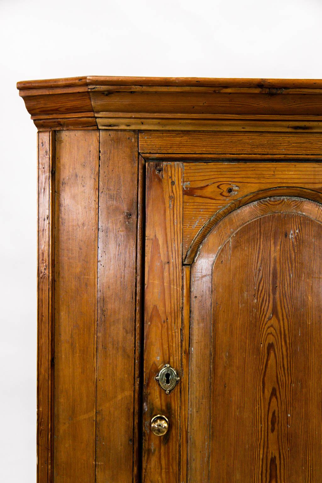 This English corner cupboard has a double raised panel door and exposed peg construction. The door is framed with simulated bead molding. The interior has four concave shaped shelves.