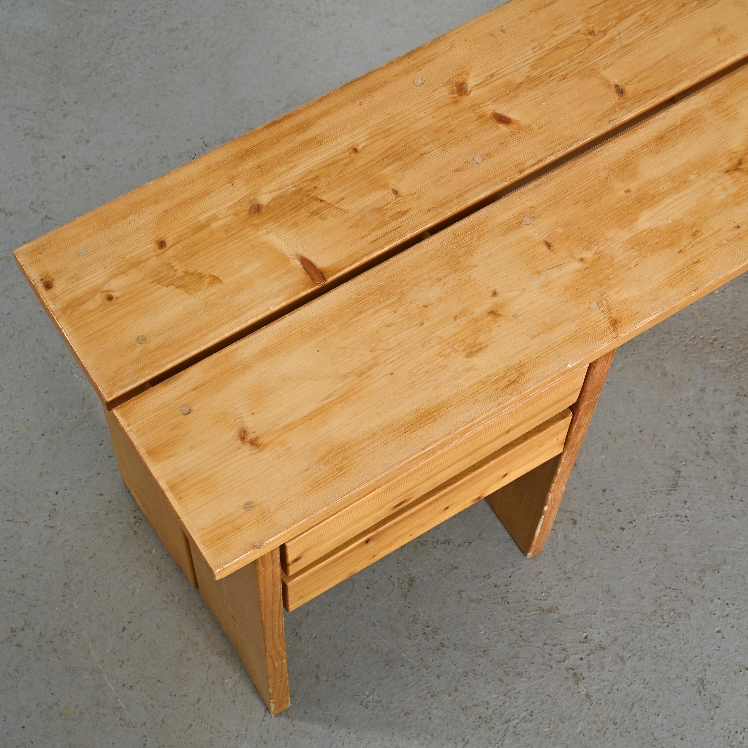 Discover this charming desk from the 1960s, a piece imbued with simplicity and elegance.

The top, cleverly designed in two parts, is joined by dowels and rests on sled-style legs. On the left side, two thoughtfully integrated drawers provide