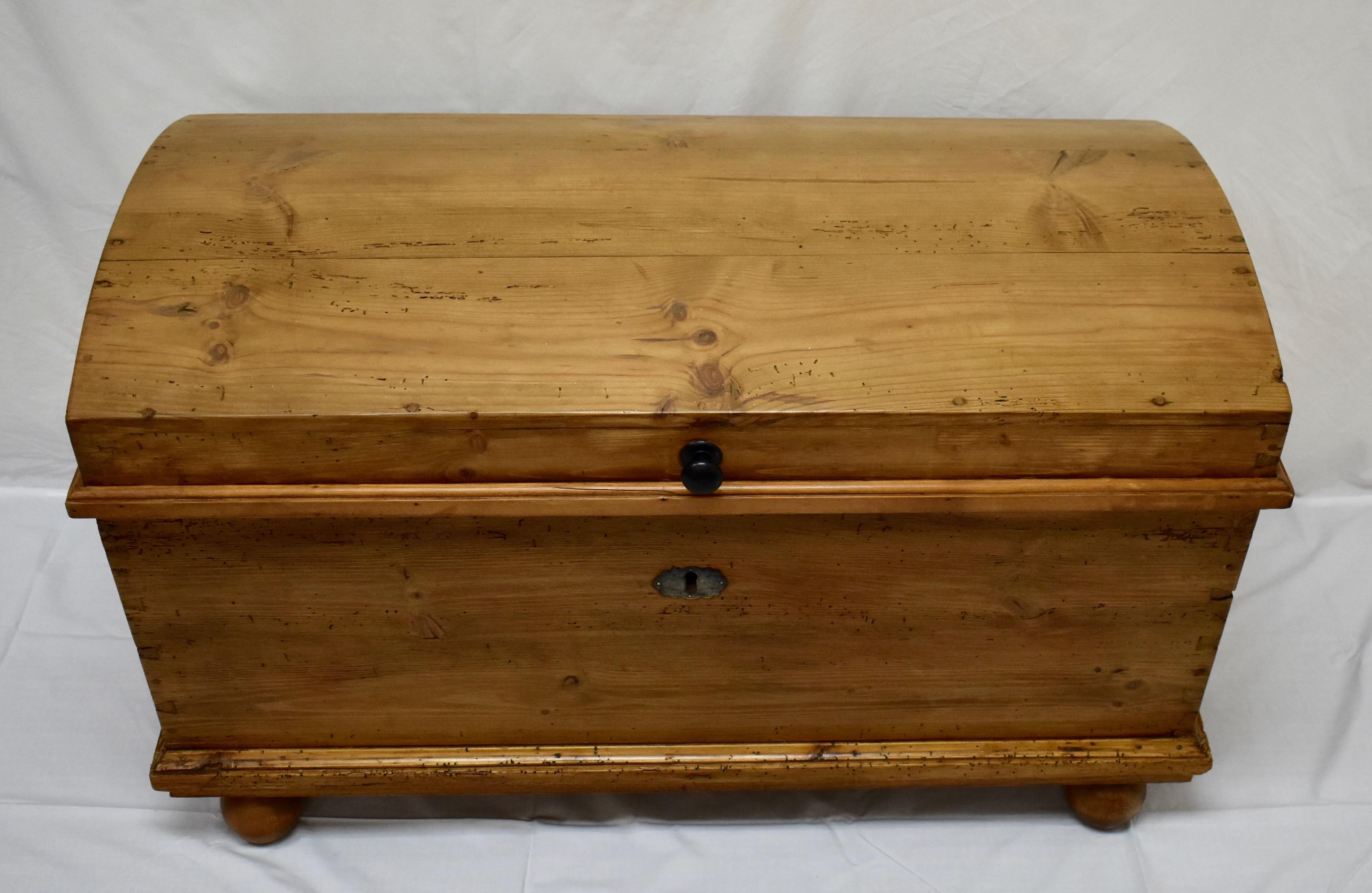 This is a very handsome pine dome-top trunk, the four board top in very good order and attached entirely with wooden pegs. The sides are beautifully tapered, with original iron handles. There are exposed handcut dovetails on the corners, bold