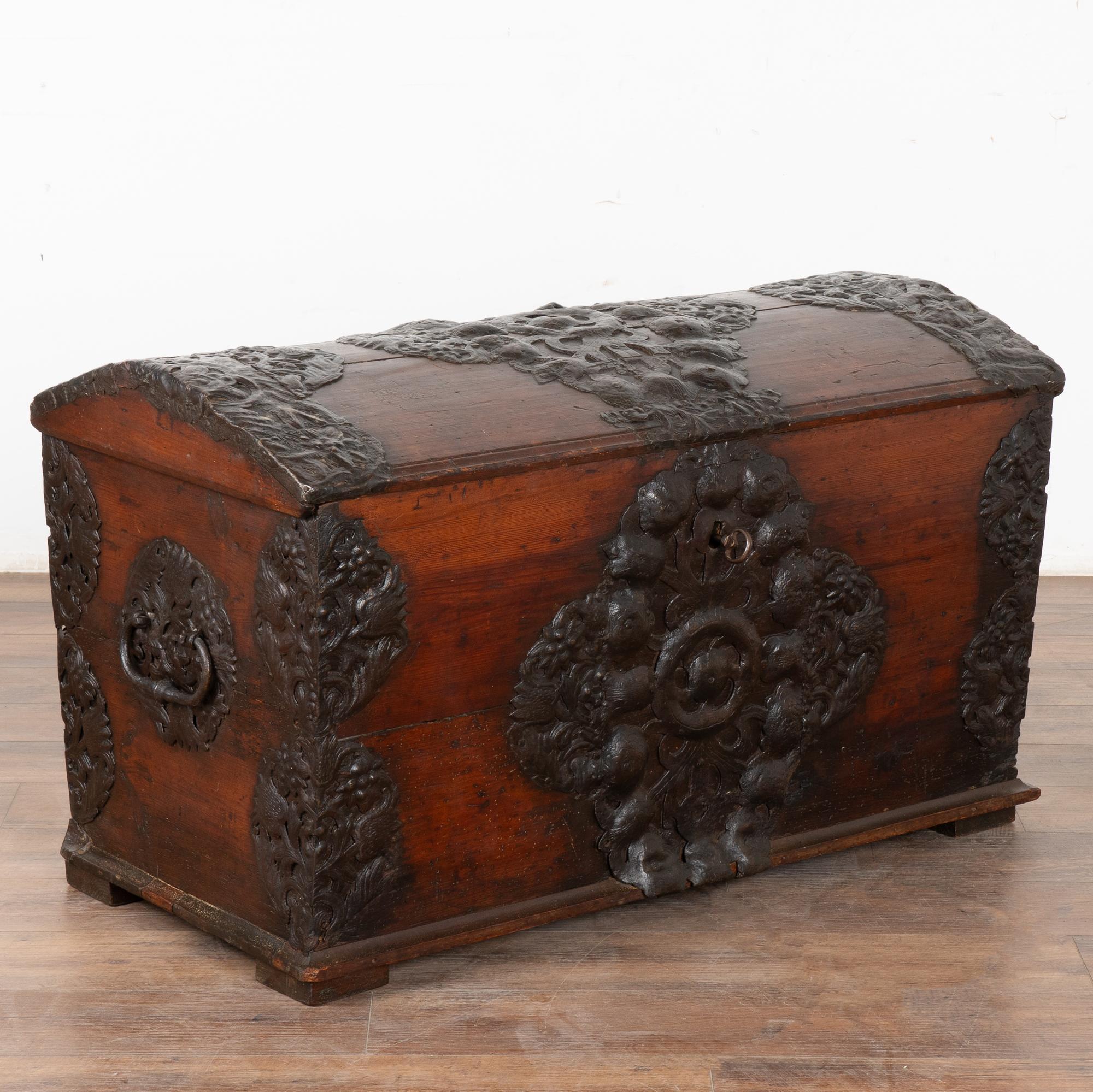 Ce sont les incroyables détails en fer forgé à la main qui font de cette malle à dôme une trouvaille exceptionnelle. Notez les fleurs élaborées que l'on retrouve dans l'ensemble de la ferronnerie, entourant le dessus, les coins et même le