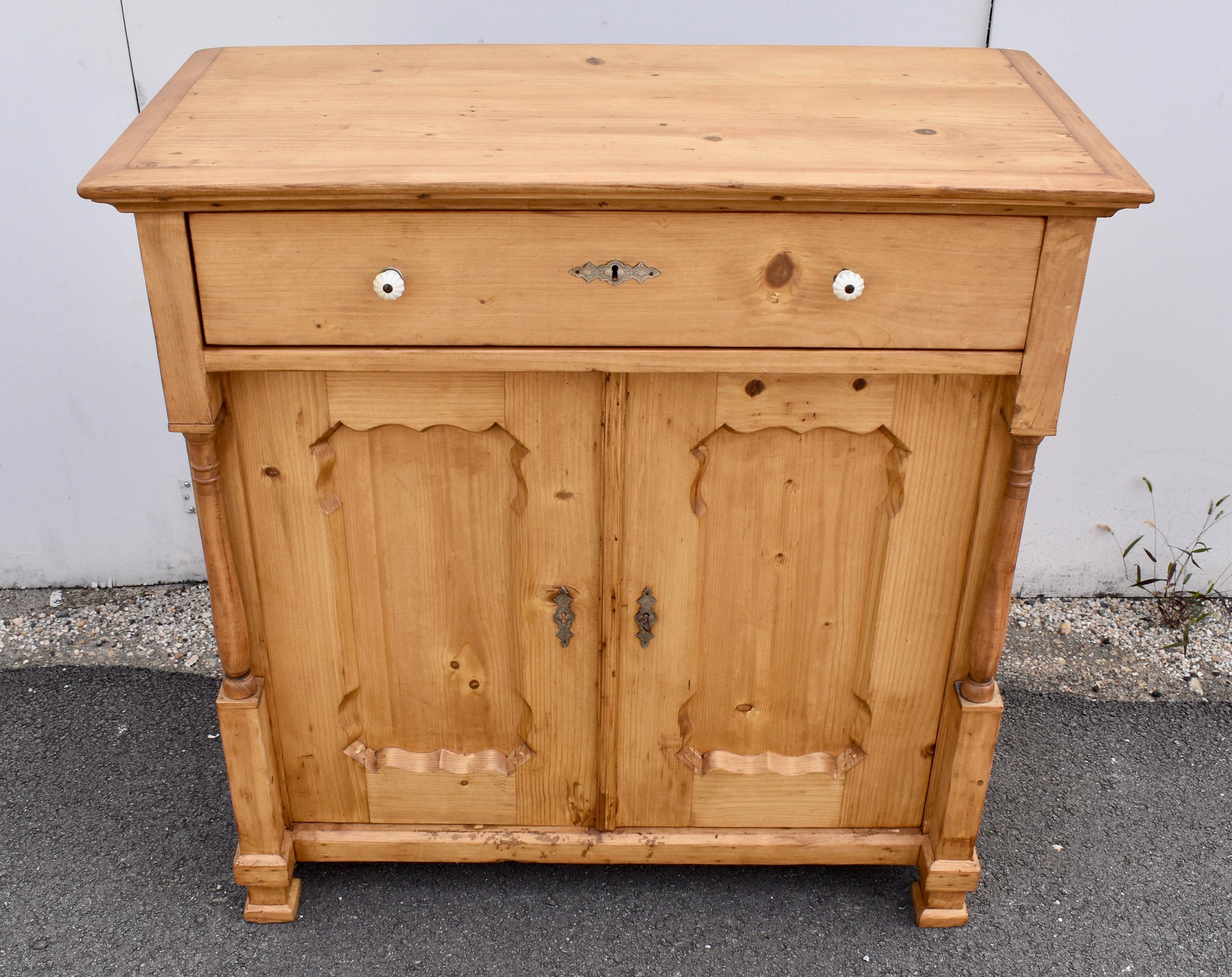 This handsome two door base features very clear wood, hand-polished to a warm honey glow.  The top has a bold crown molding above a single long hand-cut dovetailed drawer which stands proud of the doors with their scalloped frames bordering deeply