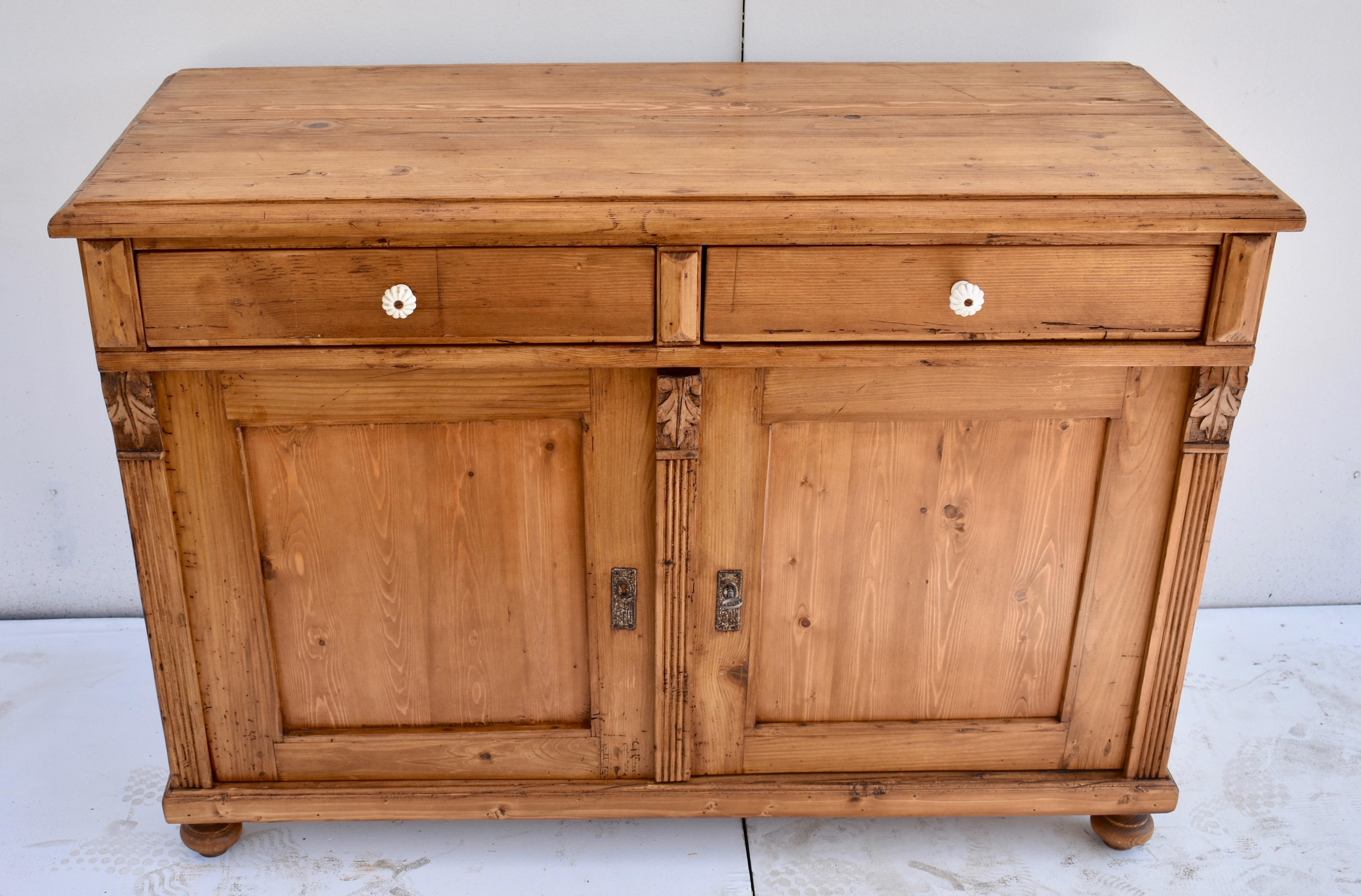 This is a very good-looking and versatile two door dresser base, with nice clear wood and a lovely warm honey color. The top has a bold step-down routed edge which sits above two shallow lap-joined drawers. The flat-paneled doors are flanked and