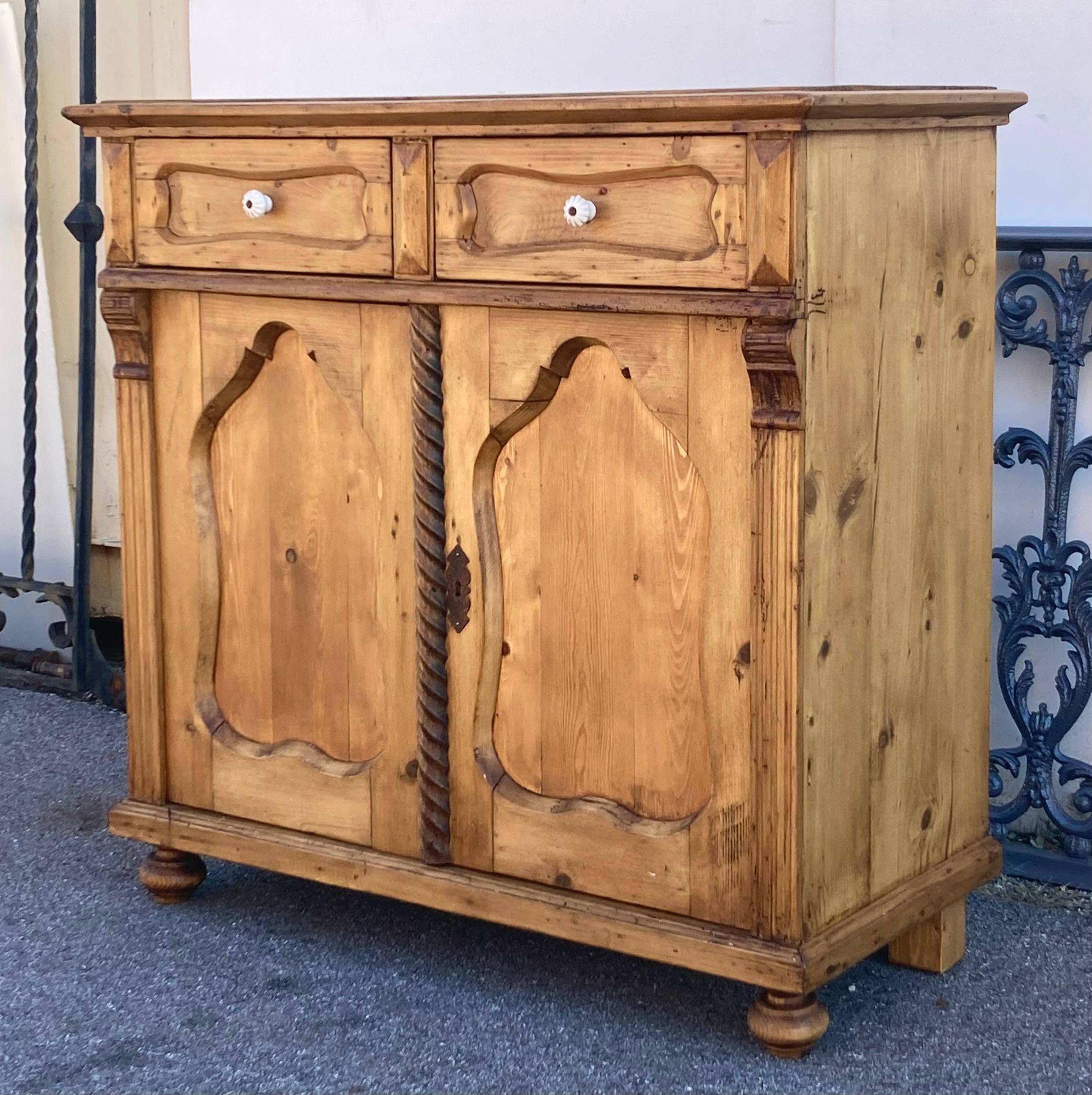  A bold ogee molding is pinned onto the top of the case of this splendid dresser base, to create a nicely formed step down edge.  Two short hand-cut dovetailed drawers with deep and shapely faux paneled fronts are flanked and separated with