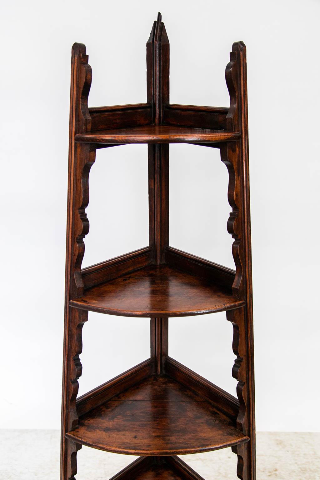 The shelves of this stand each have a shaped rear gallery and are graduated top to bottom from small to large. The side legs have applied shaped shelf supports that continue to the toes of the shelf.