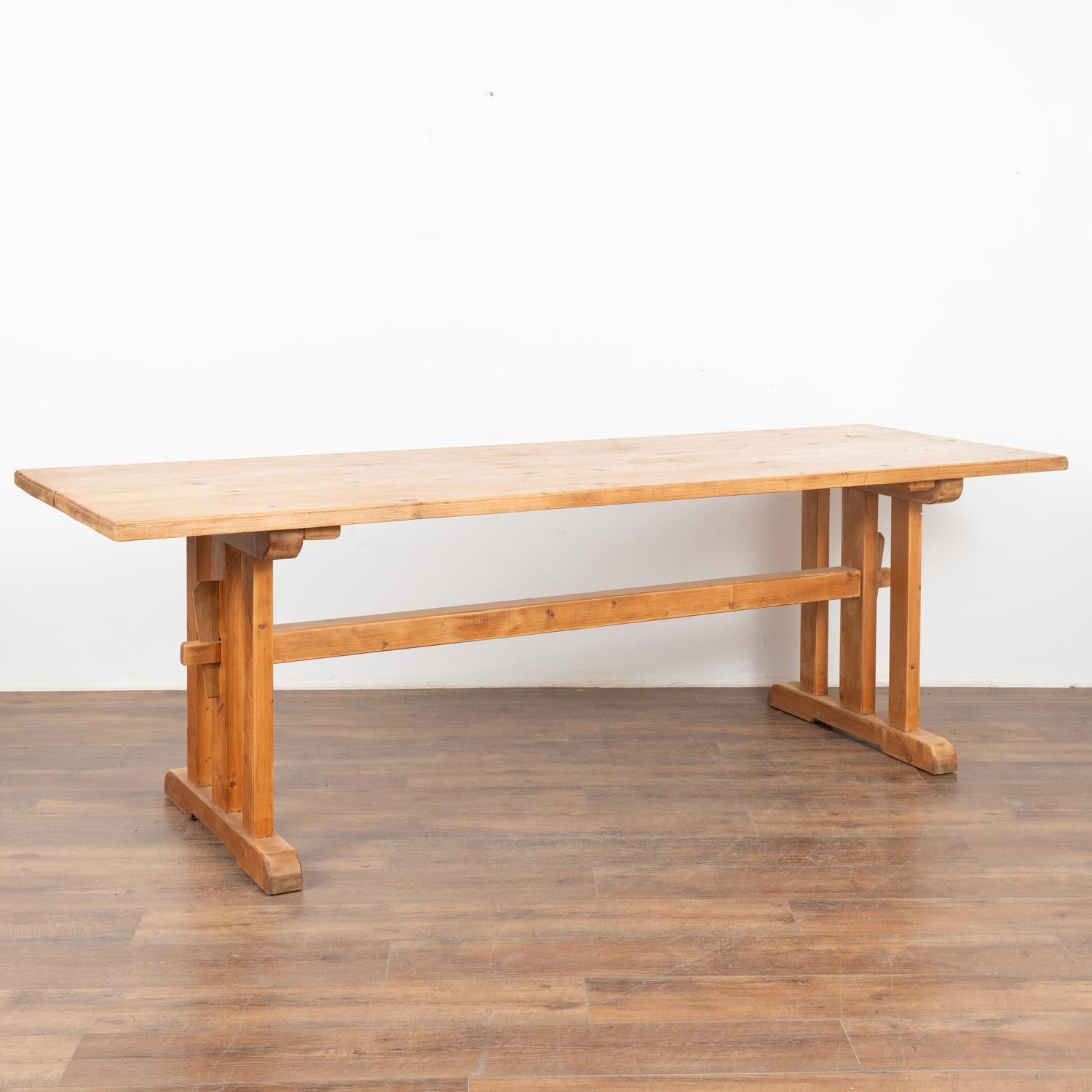 It is the long stretcher and wide platform feet of the base that give this wonderful pine trestle table it's country charm in addition to strength and stability.
The top reveals old scratches, cracks, stains, nicks, etc. which all add to the