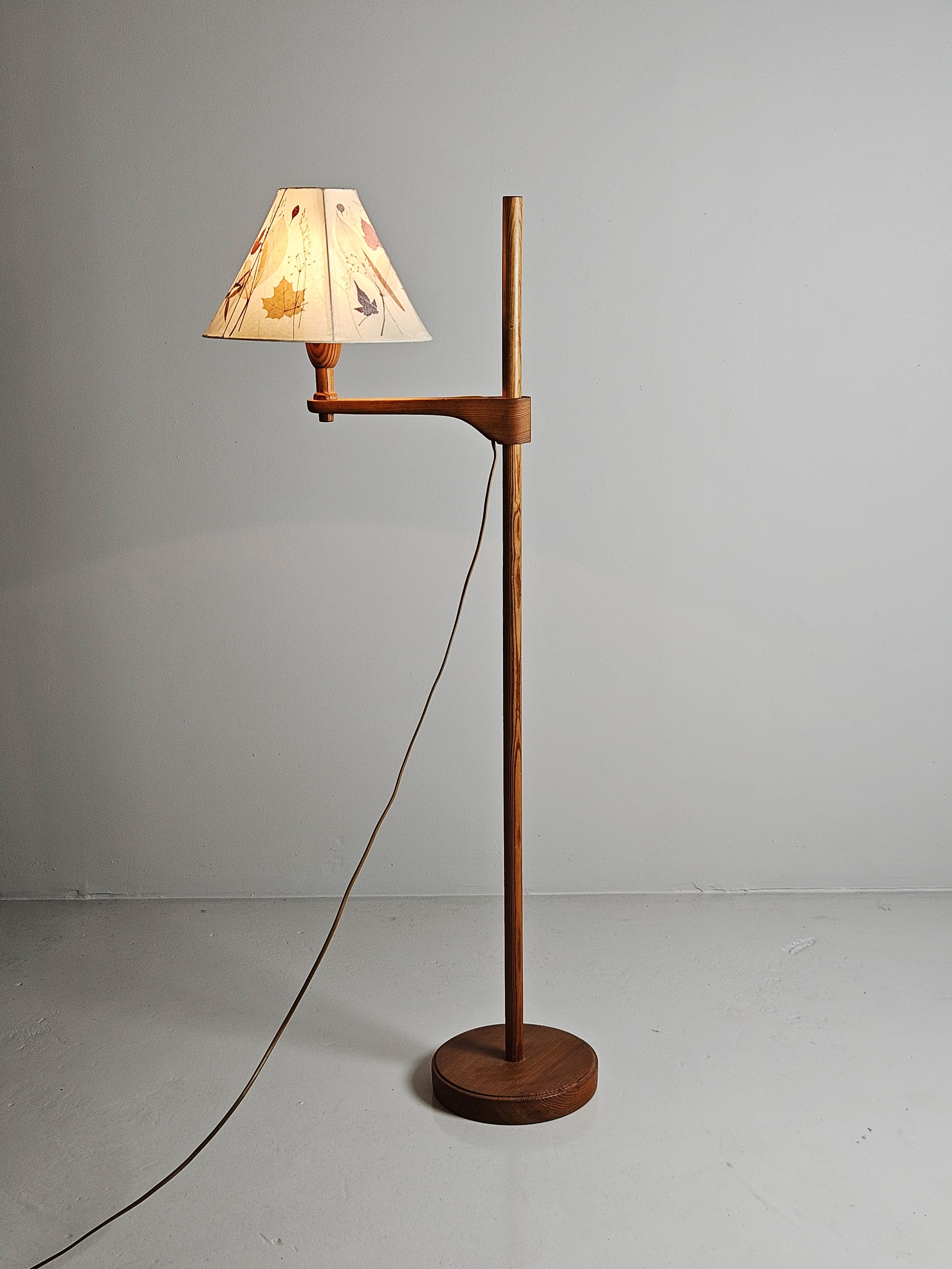 Beautiful floor lamp designed by Carl Malmsten during the 1940s.

Adjustable height. Made in pine with a beautiful shade with dryed flowers pressed on paper. 


