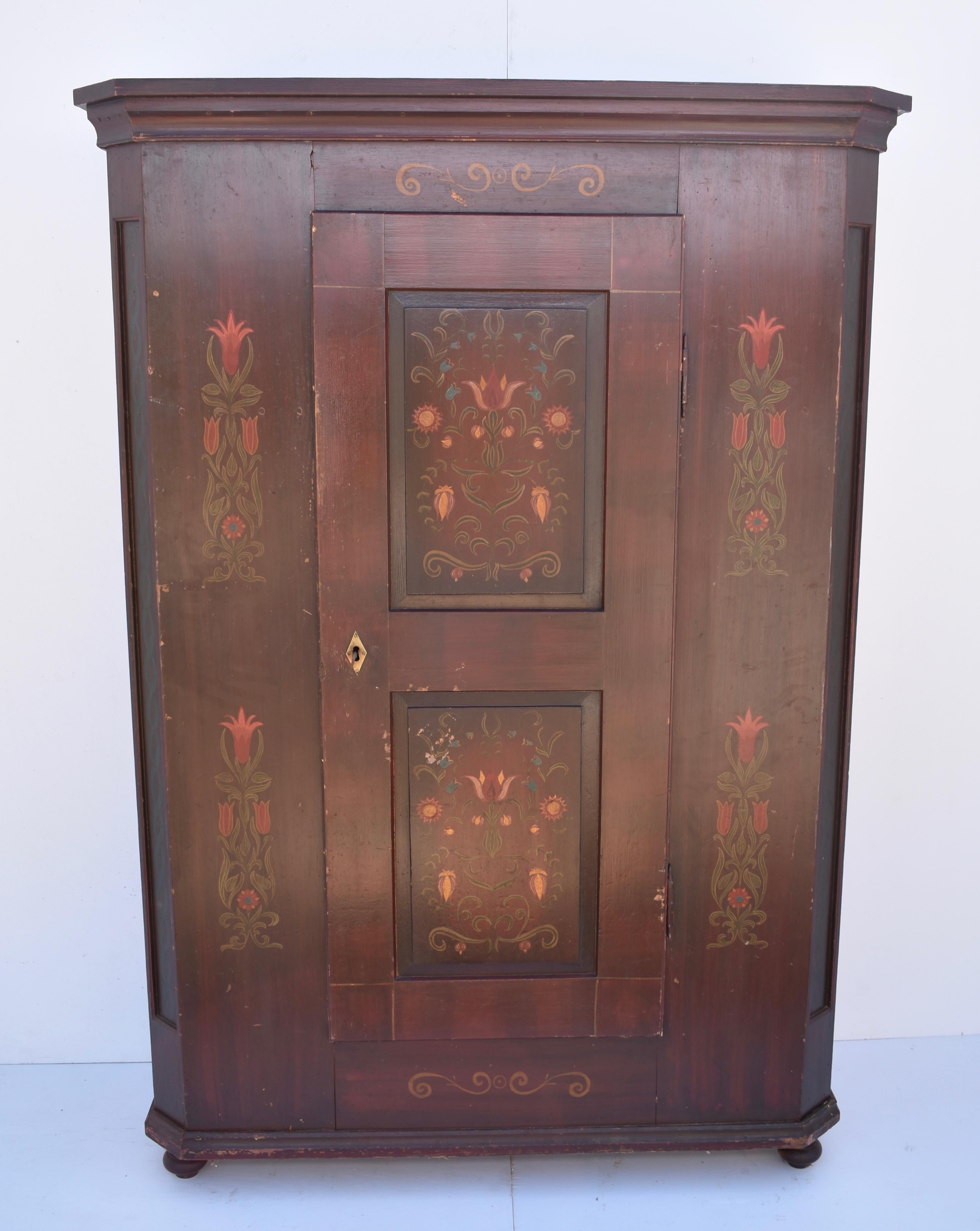 This well-built Baroque-style wardrobe has a bold, nicely-formed crown, a single door with two raised panels, which opens 180 degrees on fiche hinges, and unusual decorated panels on the chamfered front corners. The whole piece is decorated with