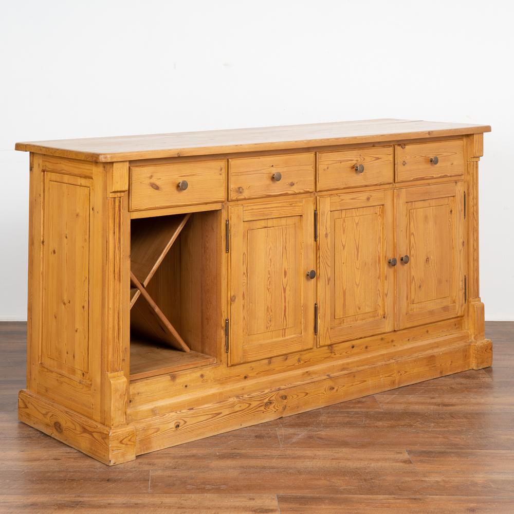 This pine shop counter is a replica of those used throughout the 1800's in Europe. It has 3 cabinet doors revealing interior storage while the left section is designed to hold wine or other bottles. 
This country sideboard could be used as a buffet