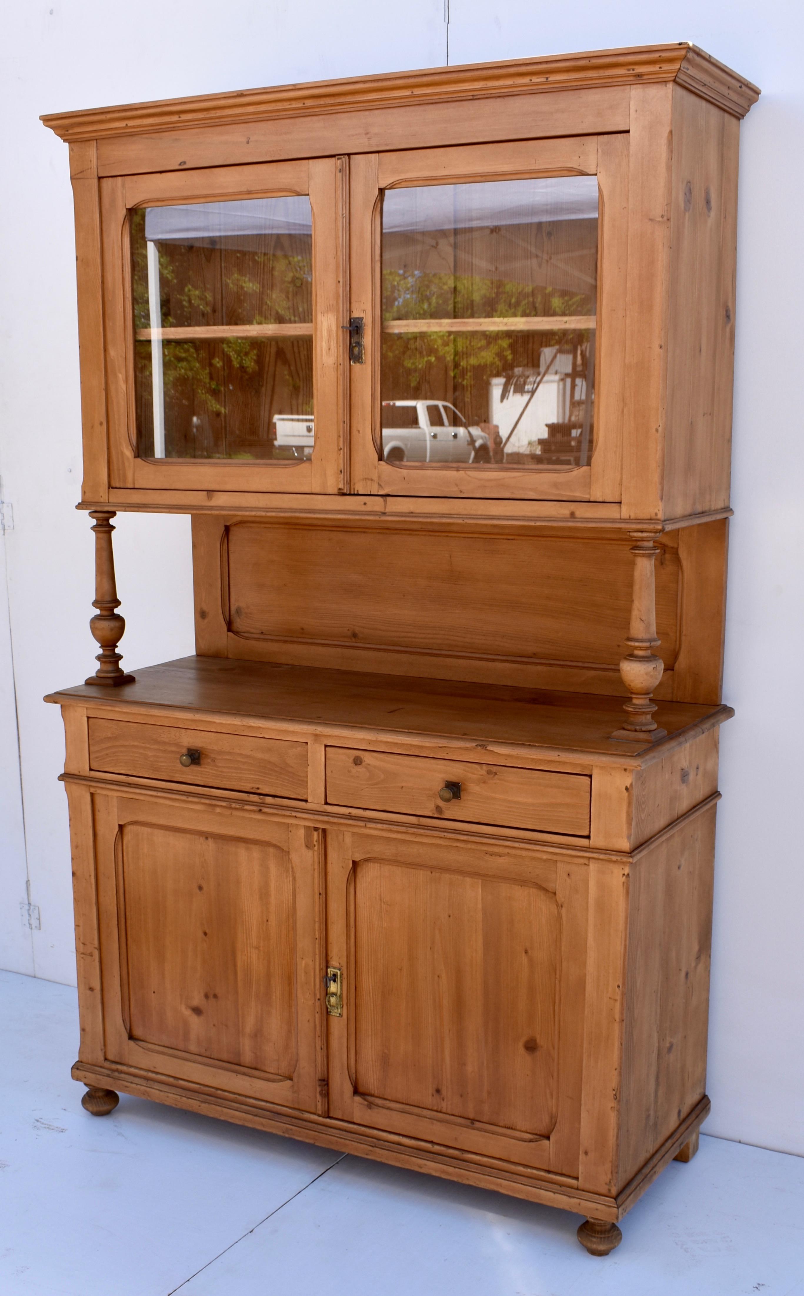 This handsome Pine Buffet has two glazed doors in the upper section and two blind doors on the lower, all with slightly rounded corners. This, as well as a chamfer on the front corners of each part are the only deviation from a very plain and simple