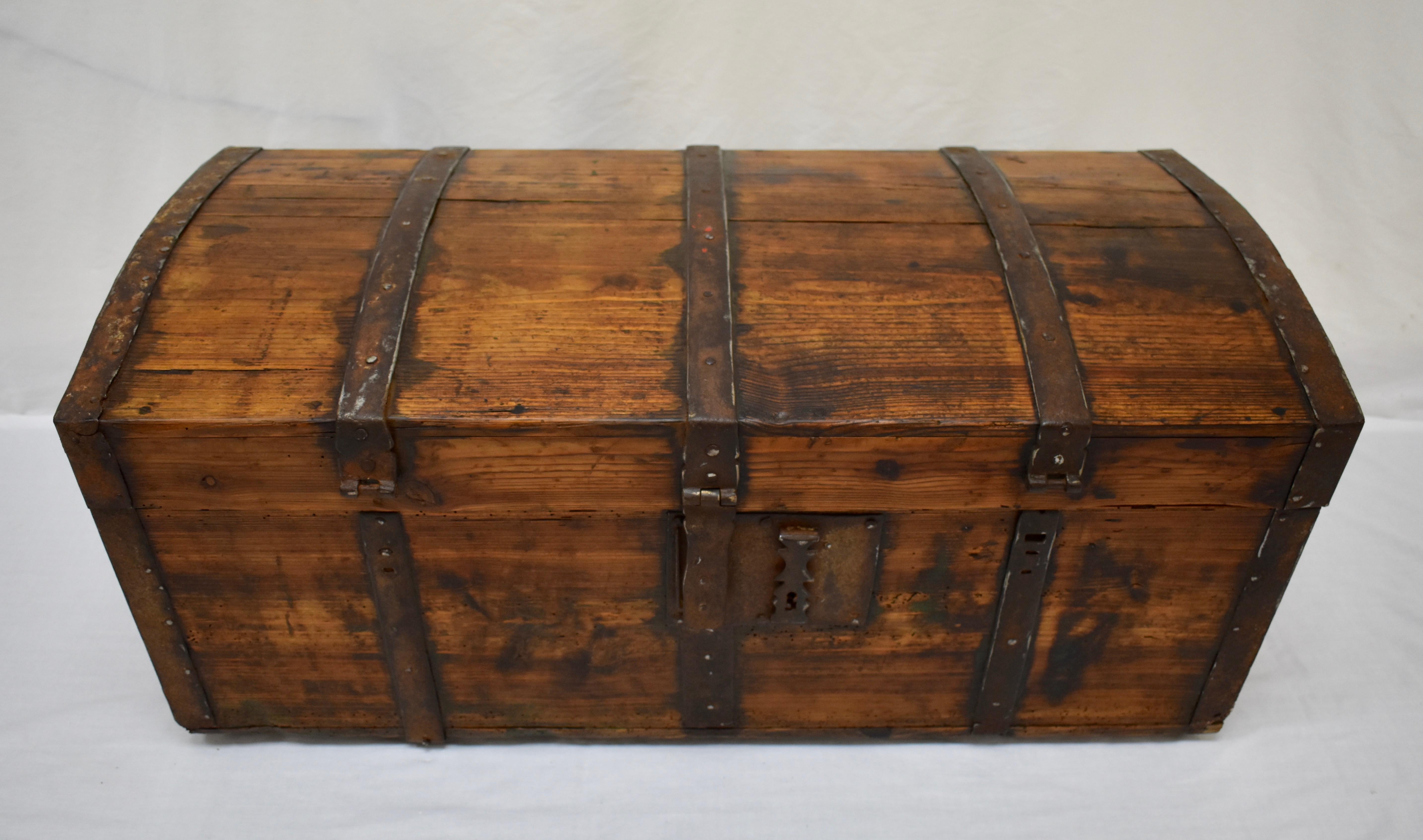 This sturdy little dome-top trunk looks just like the pirate chests in sea-faring adventure stories.  It is cleverly banded with wrought iron to prevent unauthorized entry and still retains the central and most important of its original hasps. (We