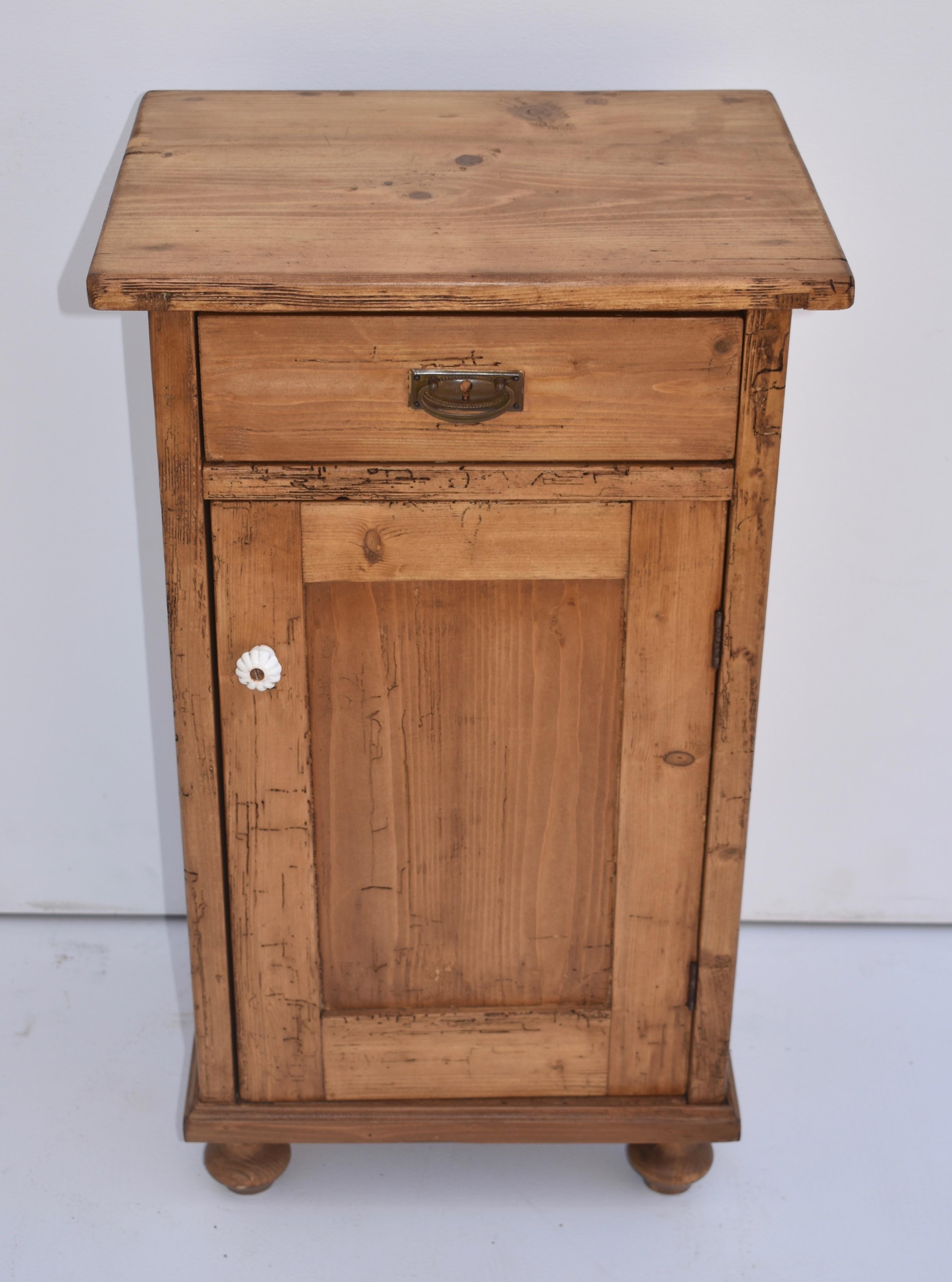 This single nightstand has one hand-cut dovetailed drawer and one paneled door, with a single shelf inside. It has significant attractive inactive woodworm tracks.