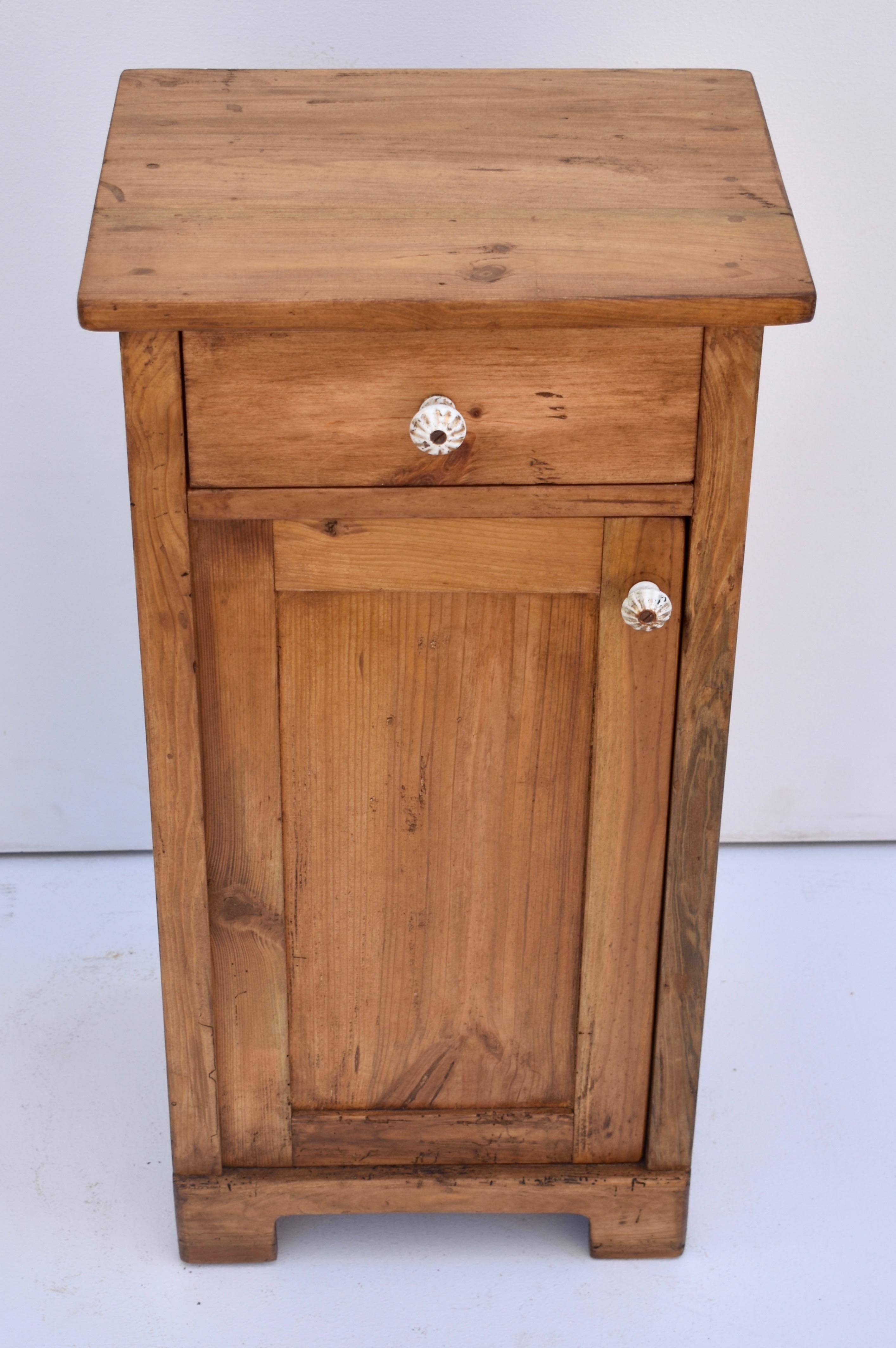 This is a plain and simple pine nightstand with one handcut dovetailed drawer and one paneled door with a single shelf inside.