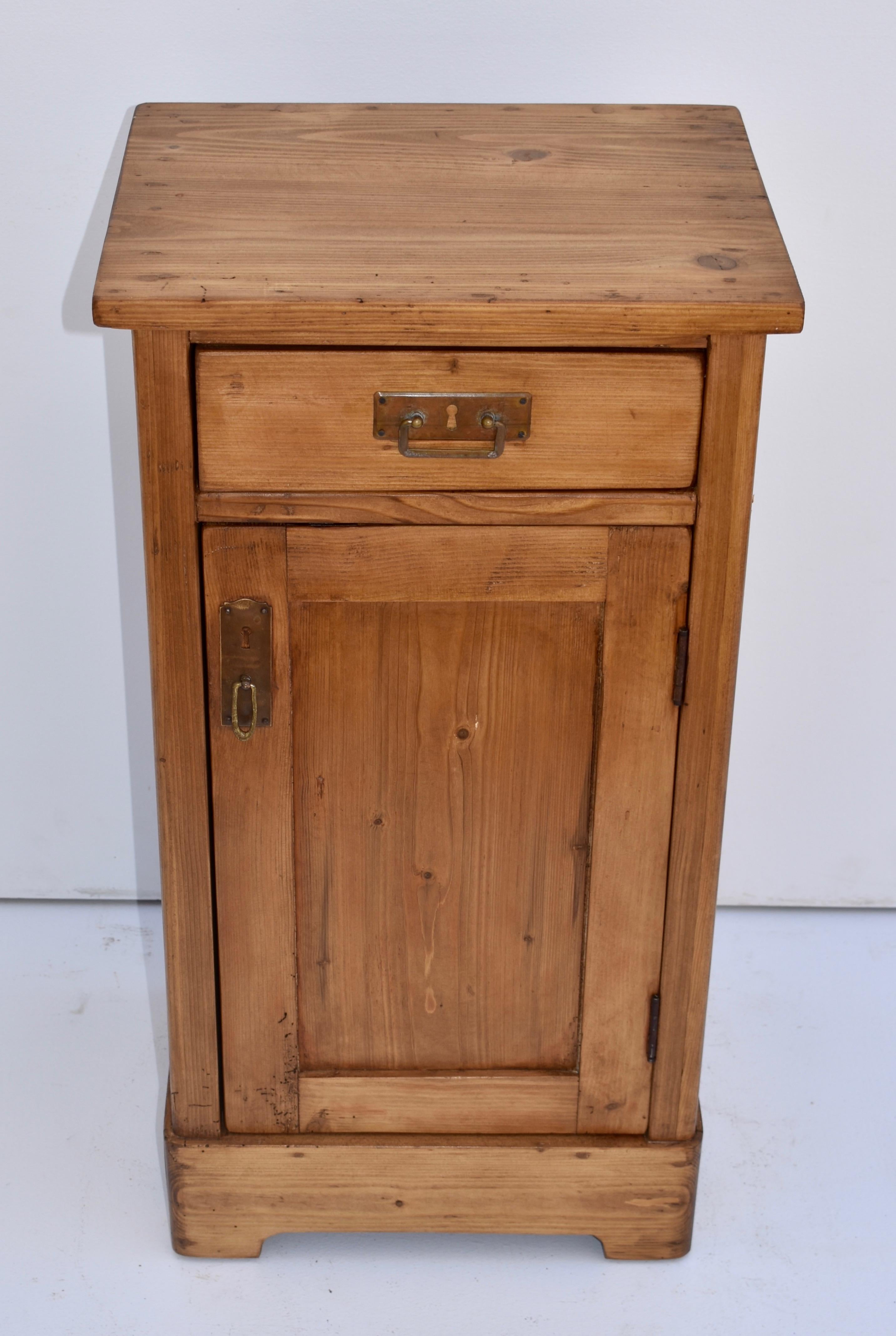 This heavy and very well-built pine nightstand has one handcut dovetailed drawer and one paneled door with a single shelf inside.