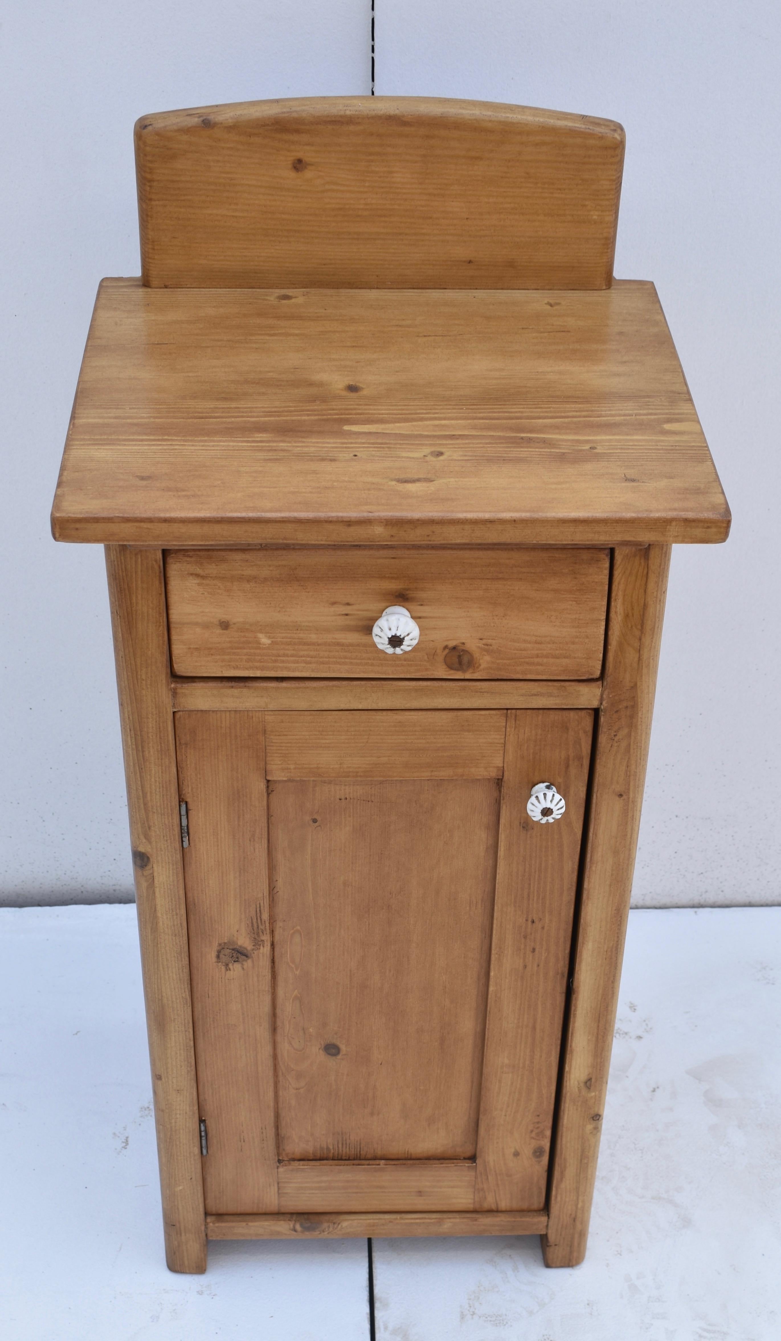 This is a plain and simple pine nightstand with one door and one hand-cut dovetailed drawer.  A six inch high splashback mounts on the top, but is easily removed without trace.  The front corners are nicely rounded, flanking the flat-paneled door. 