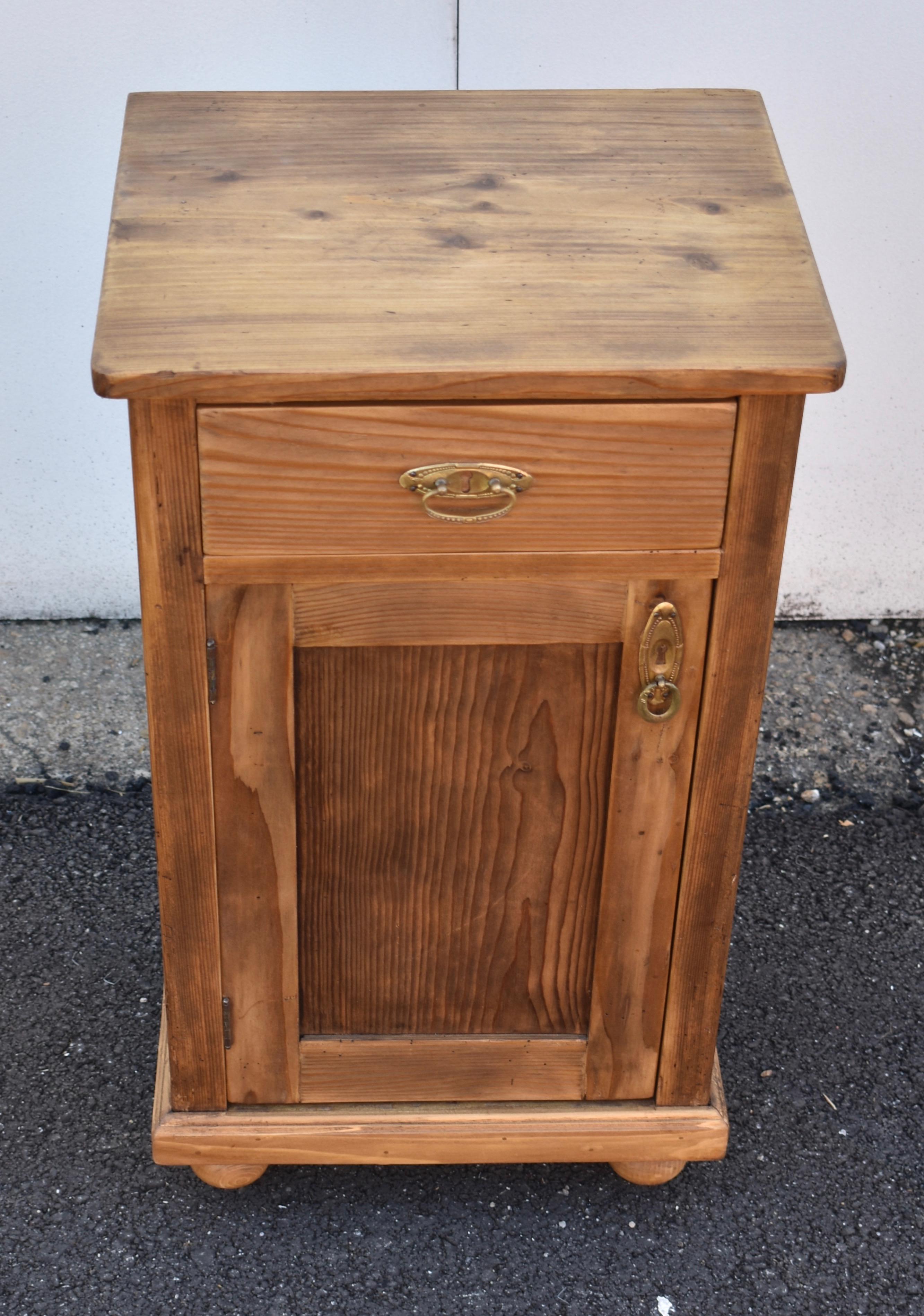 This small nightstand has a strong grain pattern and a rich rugger brown color. The drawer is beautifully dovetailed, the front corners are blunted, and both door and drawer have lovely pressed brass hardware.

 