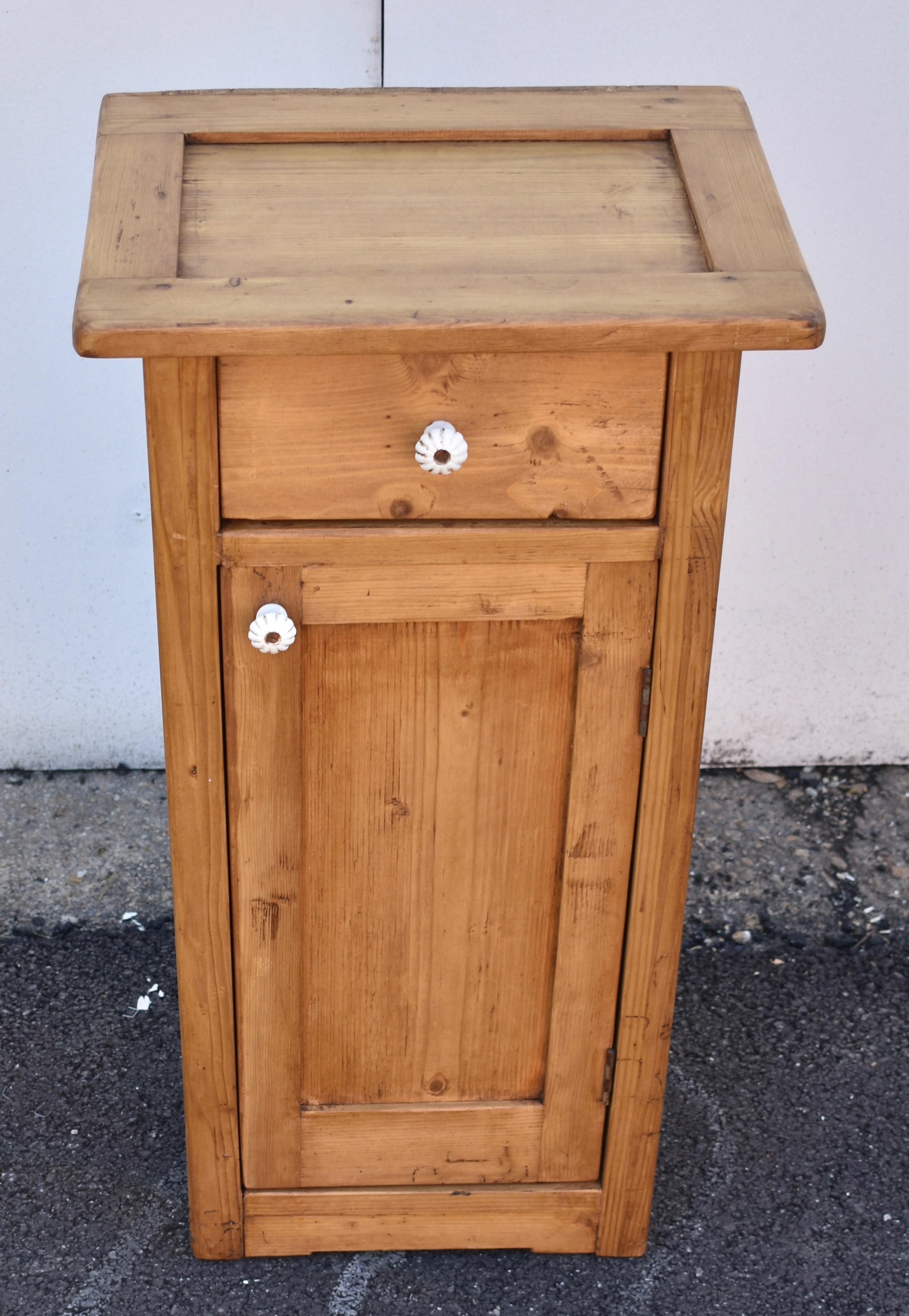 This slender nightstand has a lovely color and form with its large overhang, straight lines and clear wood. The top is recessed and may once have had a glass or marble insert. With a single drawer and a flat paneled door.


