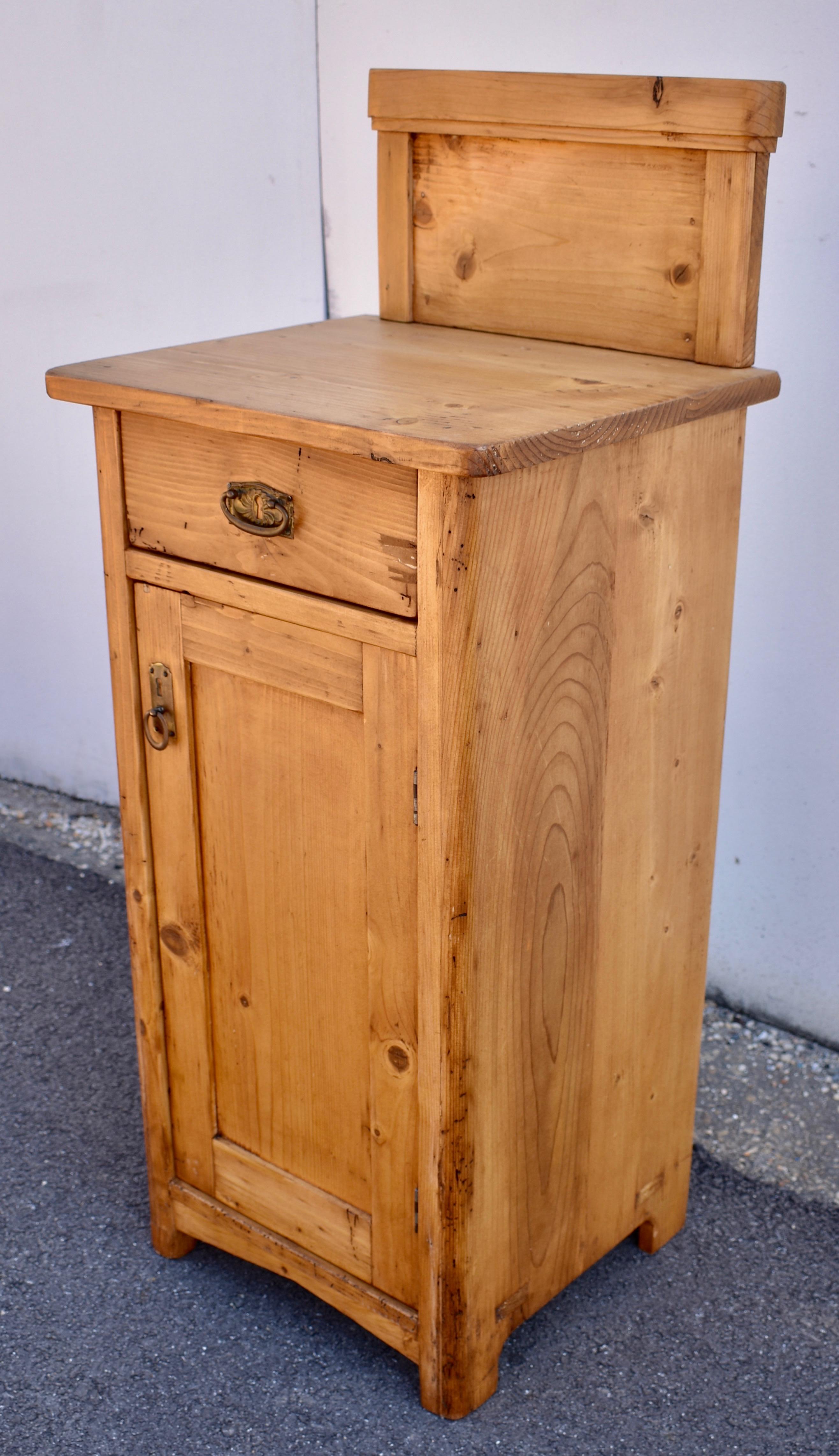 This plain and simple pine nightstand has an 8” high removable splashback to give it a 39.5” total height.  Bearing some of the scars of decades of purposeful use-some chips off the drawer front and some small dings here and there, we think this