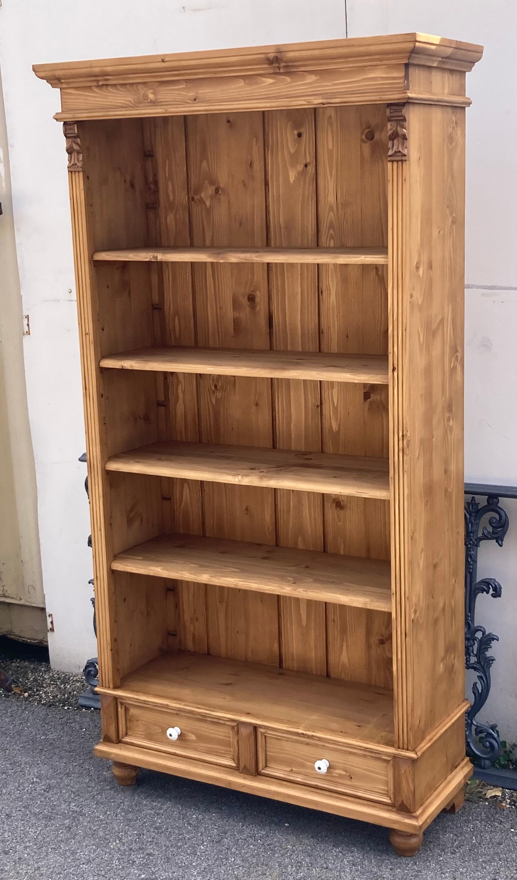 Antique pine bookcases are hard to find so the shell of this piece was provided by a vintage pine armoire.  With one board width removed from the sides and the original backboards and crown molding retained, with the two drawers reduced in depth,
