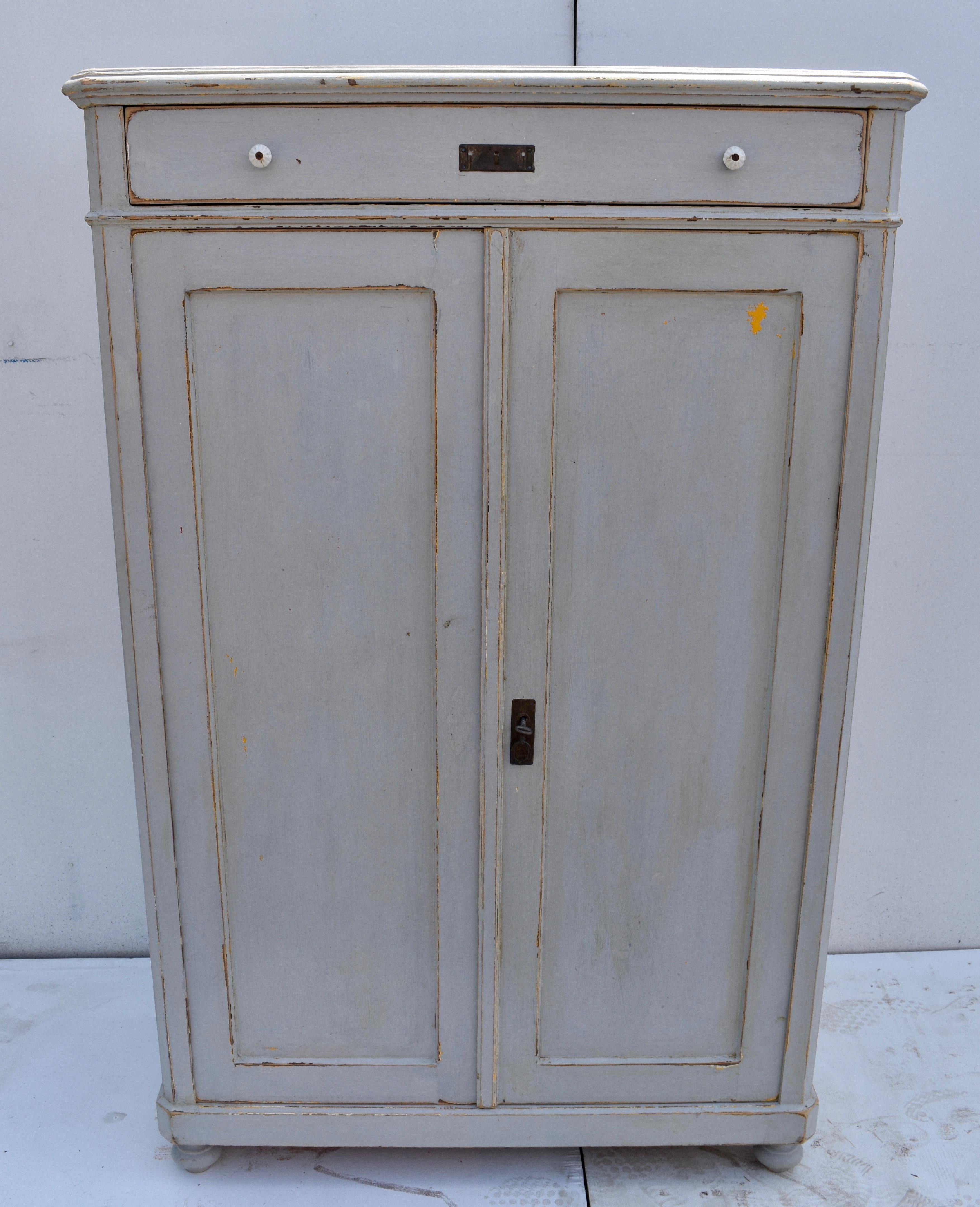 This Hungarian pine linen cabinet has a lovely form and is configured like a “vertigo”, or vertical cabinet, with the drawer placed above the two paneled doors. The top and the front corners of the case are chamfered in the French style. The