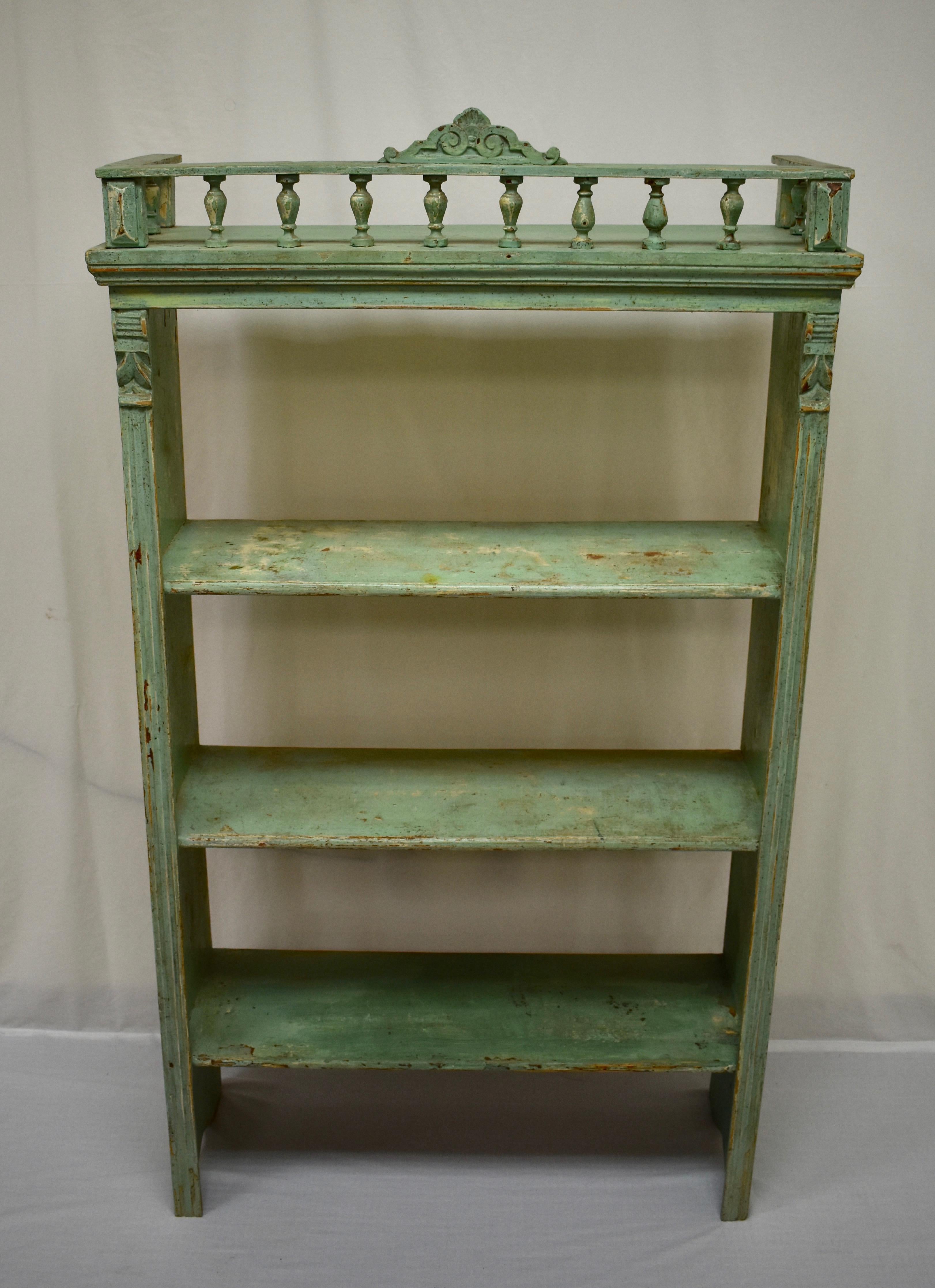 This Primitive utility shelf unit has been used for storing heavy vessels and some of them have left their marks on the shelves of this pretty piece. Three shelves are pegged into the uprights which are decorated with fluting and acanthus leaf