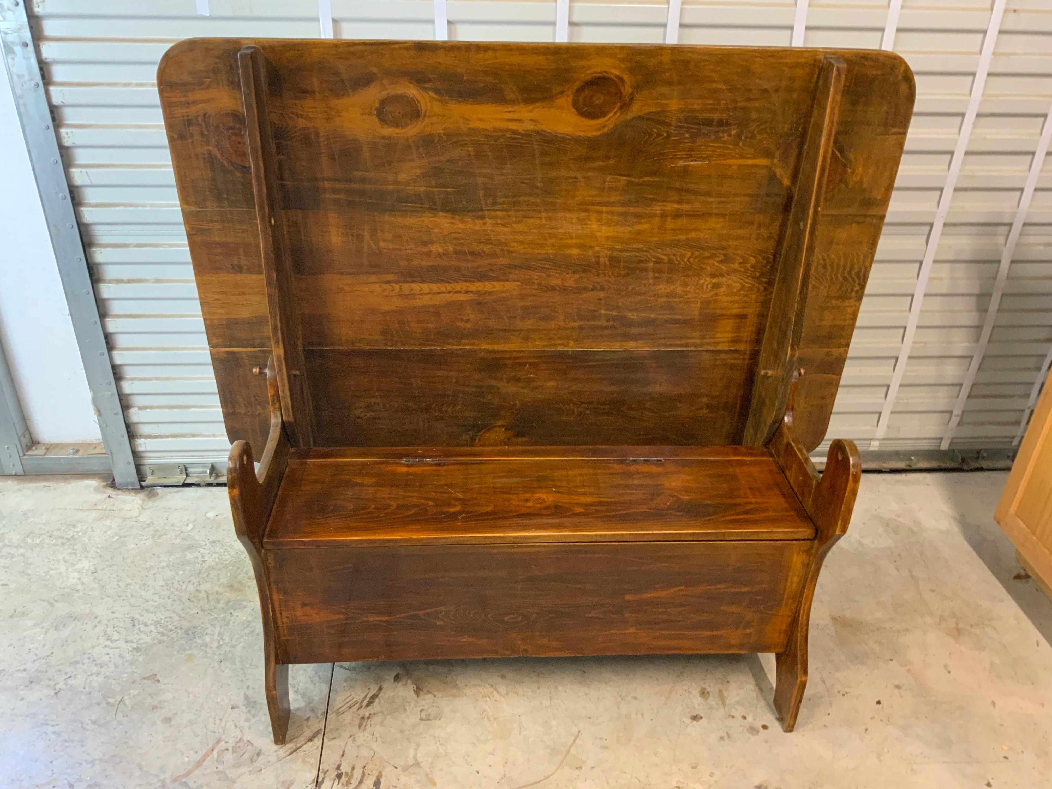 A very nice Primitive hutch table made of Pine with a three board top and a bench seat with a storage area. Looks to be made around late 1800s or early 1900s. Traces of old yellow - green paint in some areas on an older refinish surface. The pegs