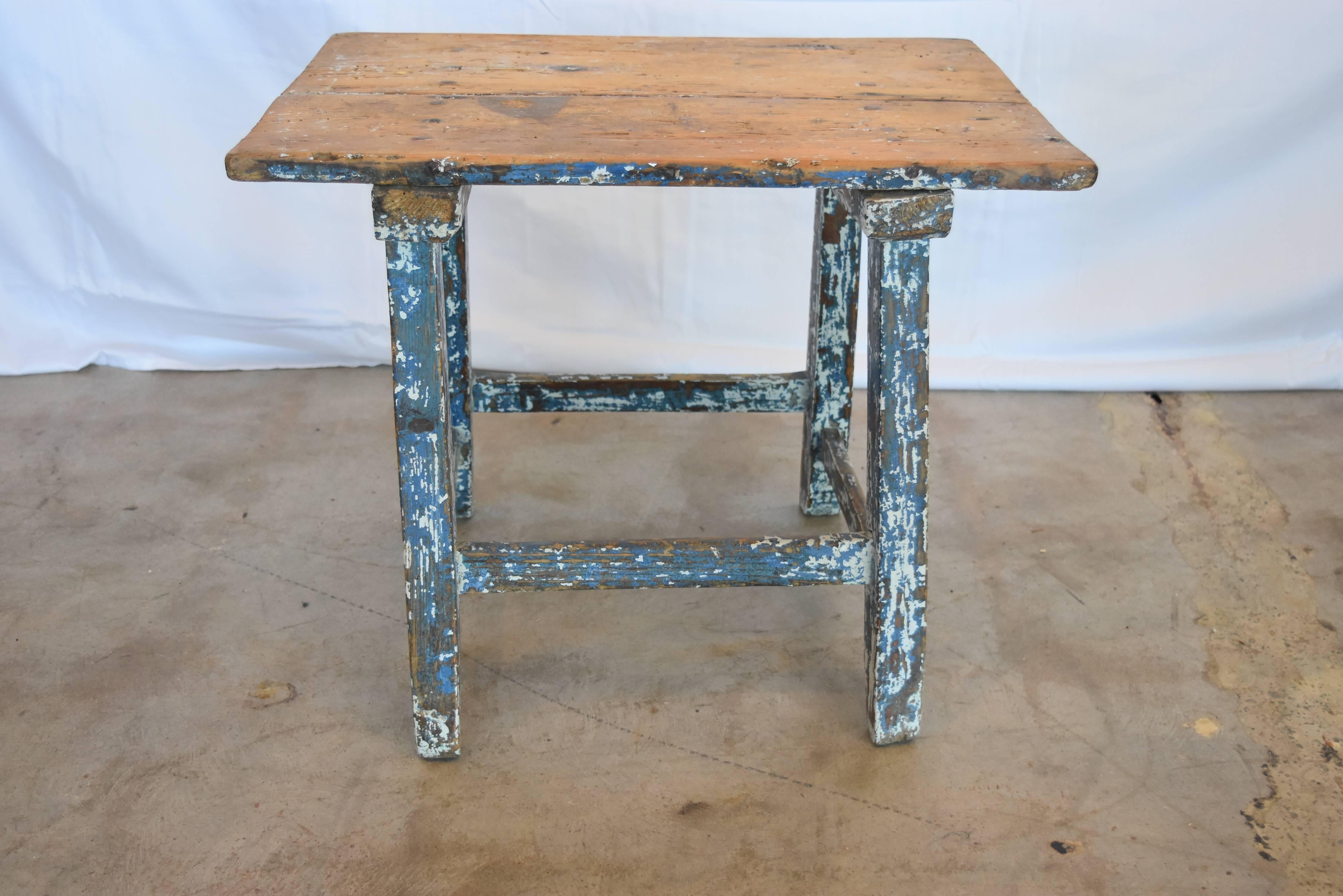 This is an early 20th century Childs table from Spain which can serve as a side table or stool as well. Much of the original paint is still intact which makes it more desirable indeed. It's very sturdy, made out of pine and the photos are a good