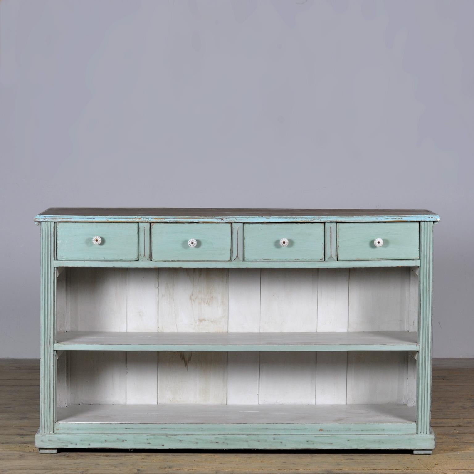 Un bellissimo bancone con quattro cassetti con pomelli in porcellana. Realizzato in legno di pino. La vernice blu conferisce al bancone un colore e un carattere eccezionali.