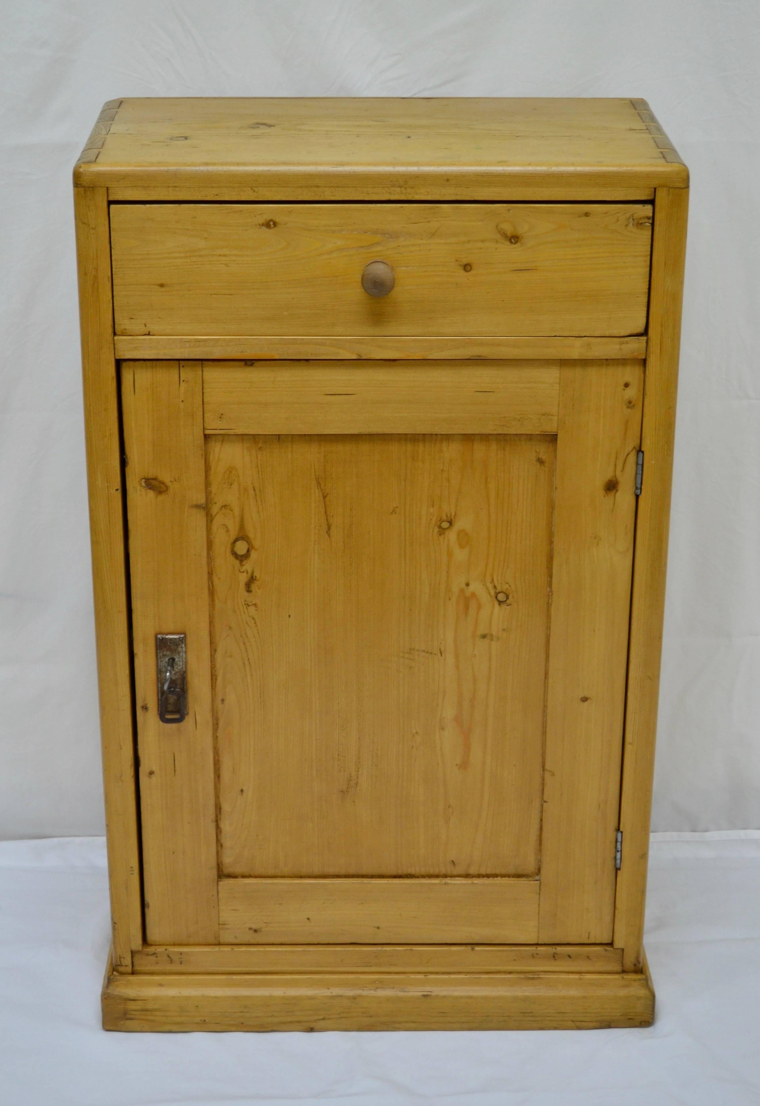 This is a very attractive and unusually shallow side cupboard with exposed hand-cut dovetails on its rounded top corners. A single hand-cut dovetailed drawer sits above a long panelled door, opening to two interior shelves.

 