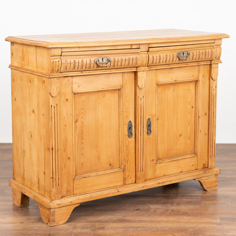 Danish pine sideboard with traditional fluted carving in drawers and along side.
Restored and waxed, this cabinet has a great interior for storage and organization with one shelf on left side and two shelves on right side.
Solid, strong and ready
