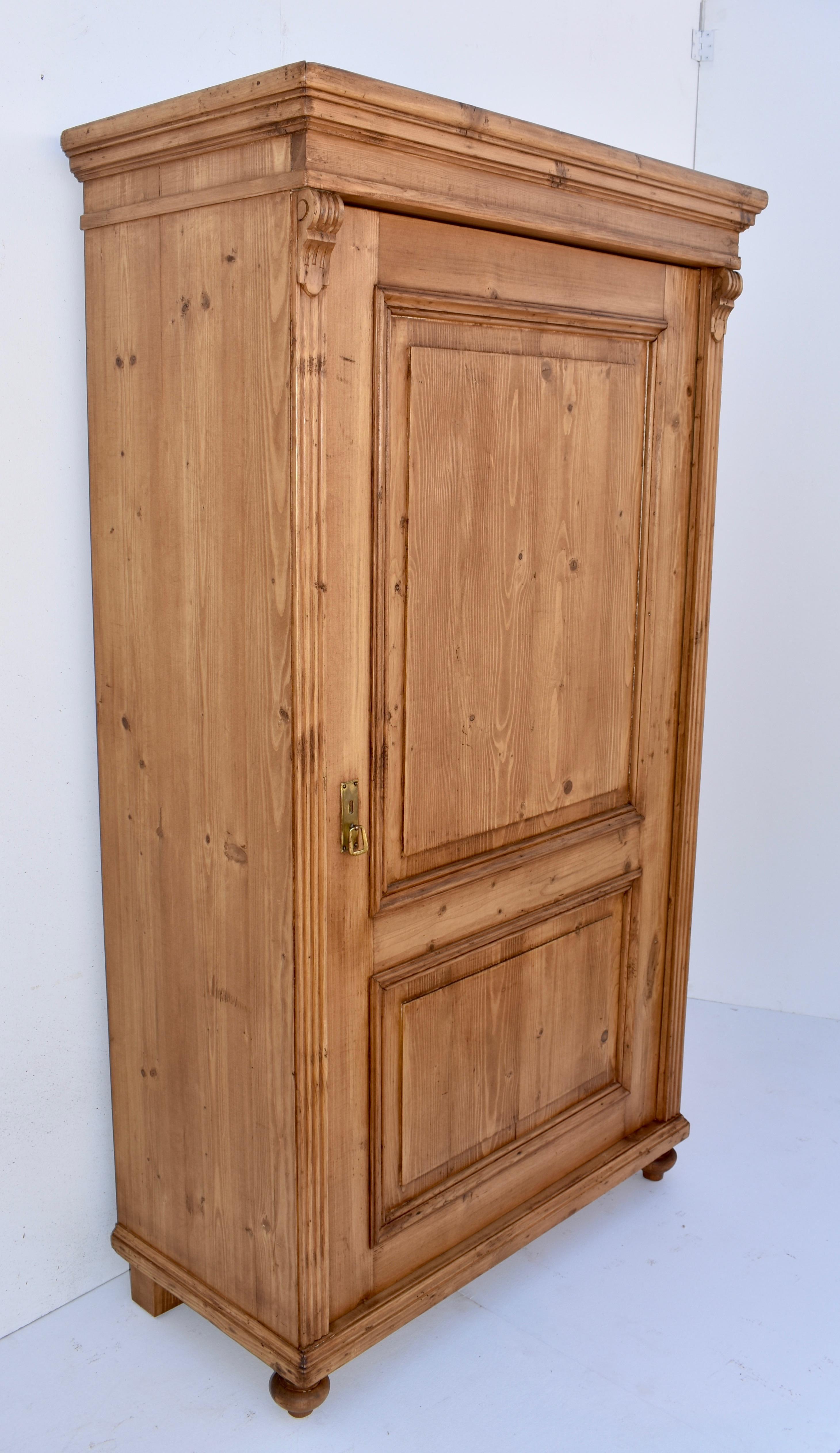 A plain and simple one door wardrobe, this piece has a bold crown molding, a door with two assymetrical raised panels and fluted front corners with carved corbels.
