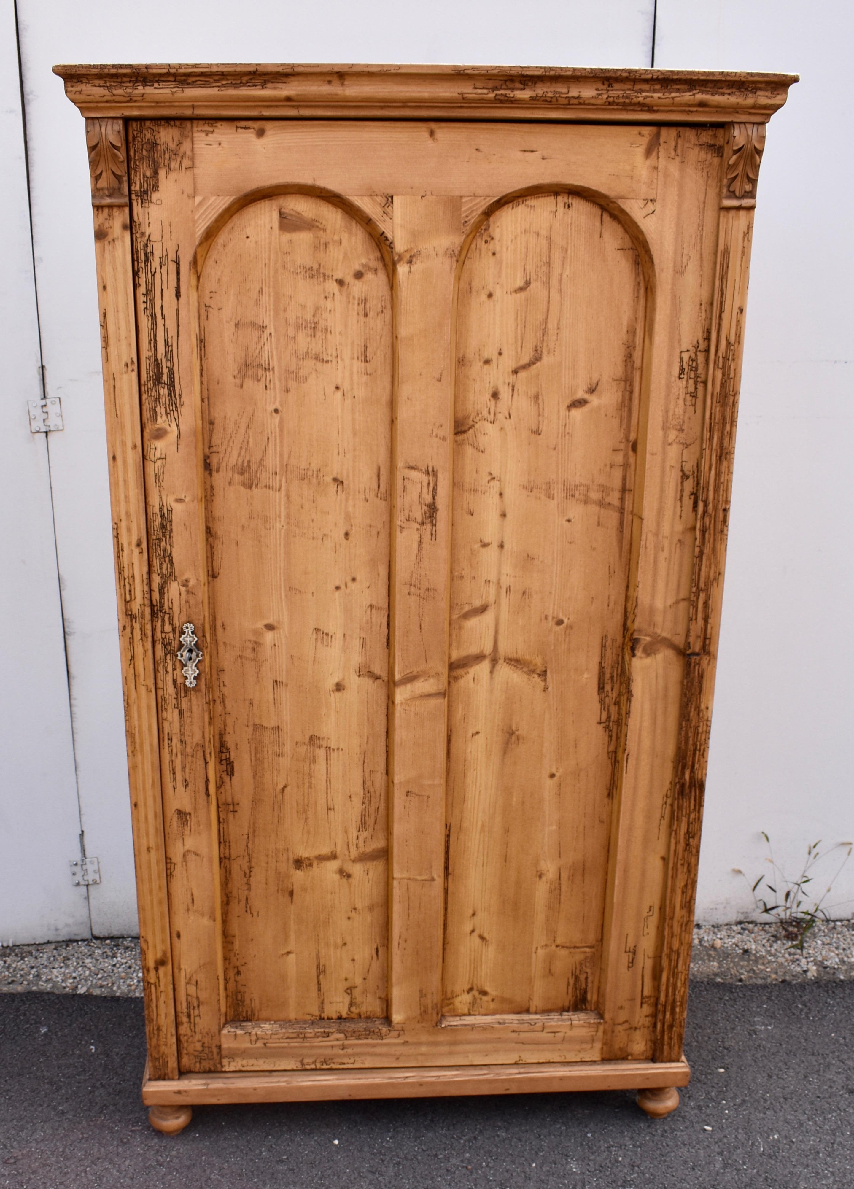 This single door armoire has extensive woodworm tracks, guaranteed to be inactive.
The crown molding is substantial and the ten inch crest with the central hardwood floral applique that surmounts it is easily removed.  The door has two long flat
