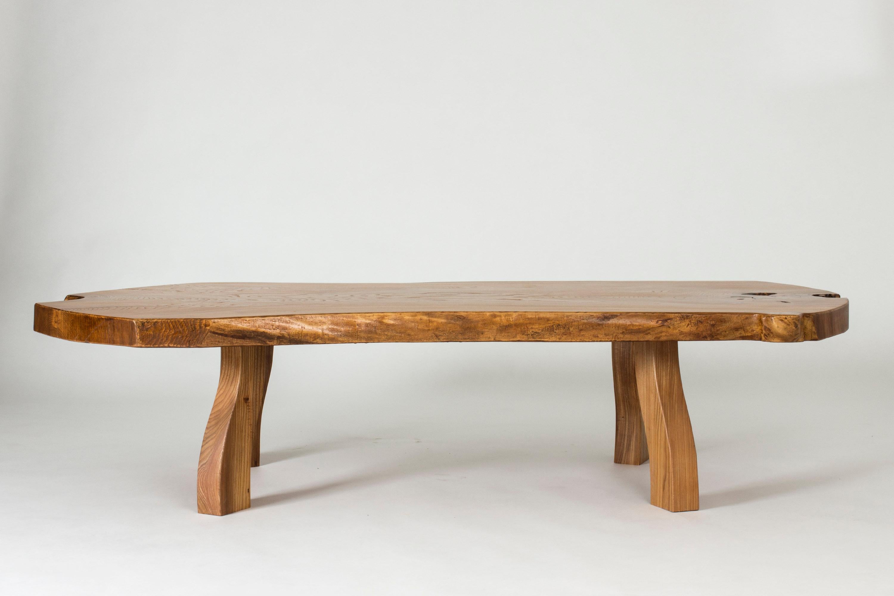 Striking elmwood coffee table by Carl-Axel Beijbom. Made from a large, thick elmwood slab with brutish, sculpted legs. Lively wood grain and accentuated knots at the far edges.