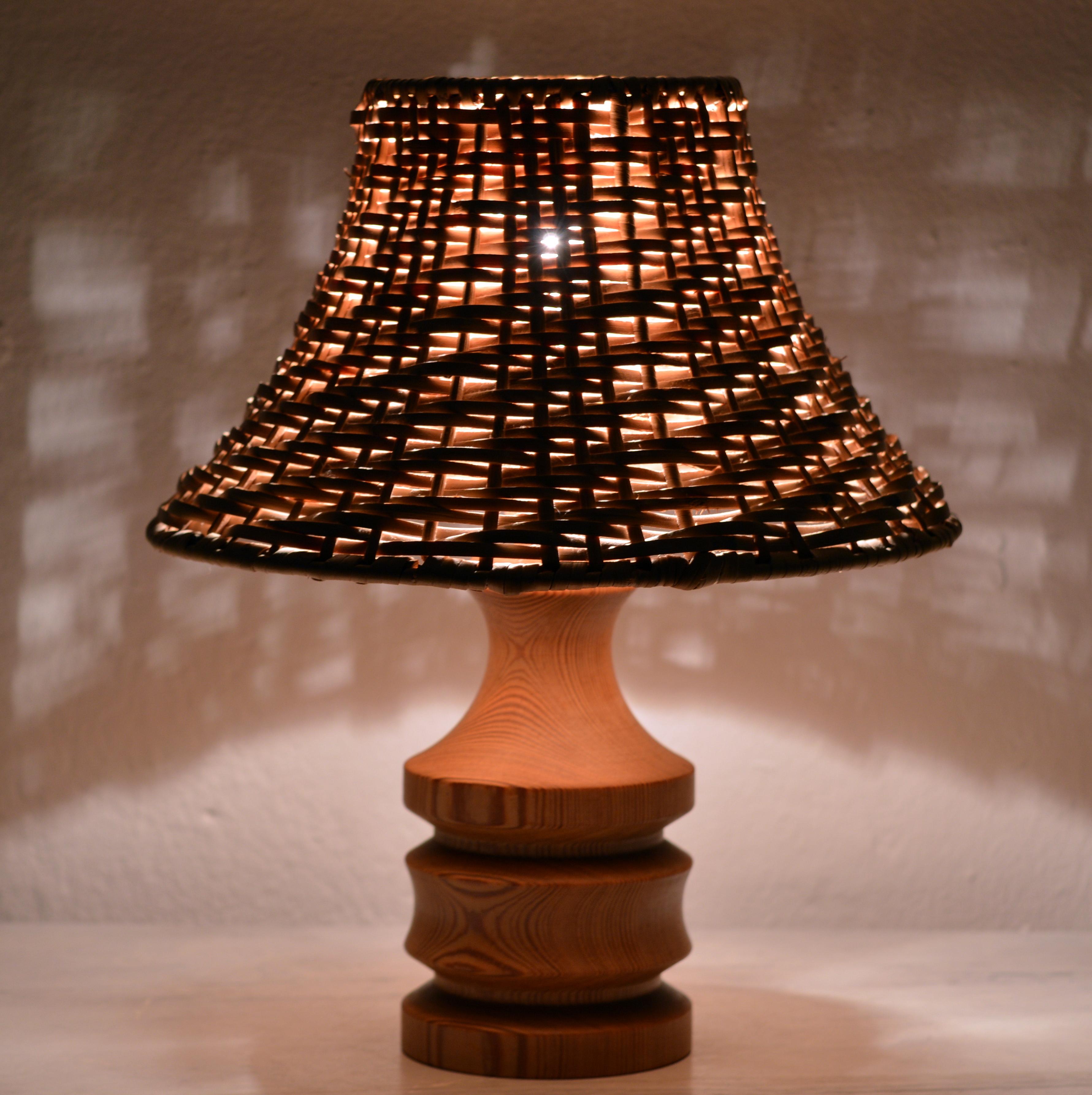 A lovely little table lamp by Swedish designer in solid pine wood with a hand-woven cane shade. Very elegant design in fine vintage condition, no chips or cracks. It takes one E14 screw base light bulb. LED bulbs can also be used. 

