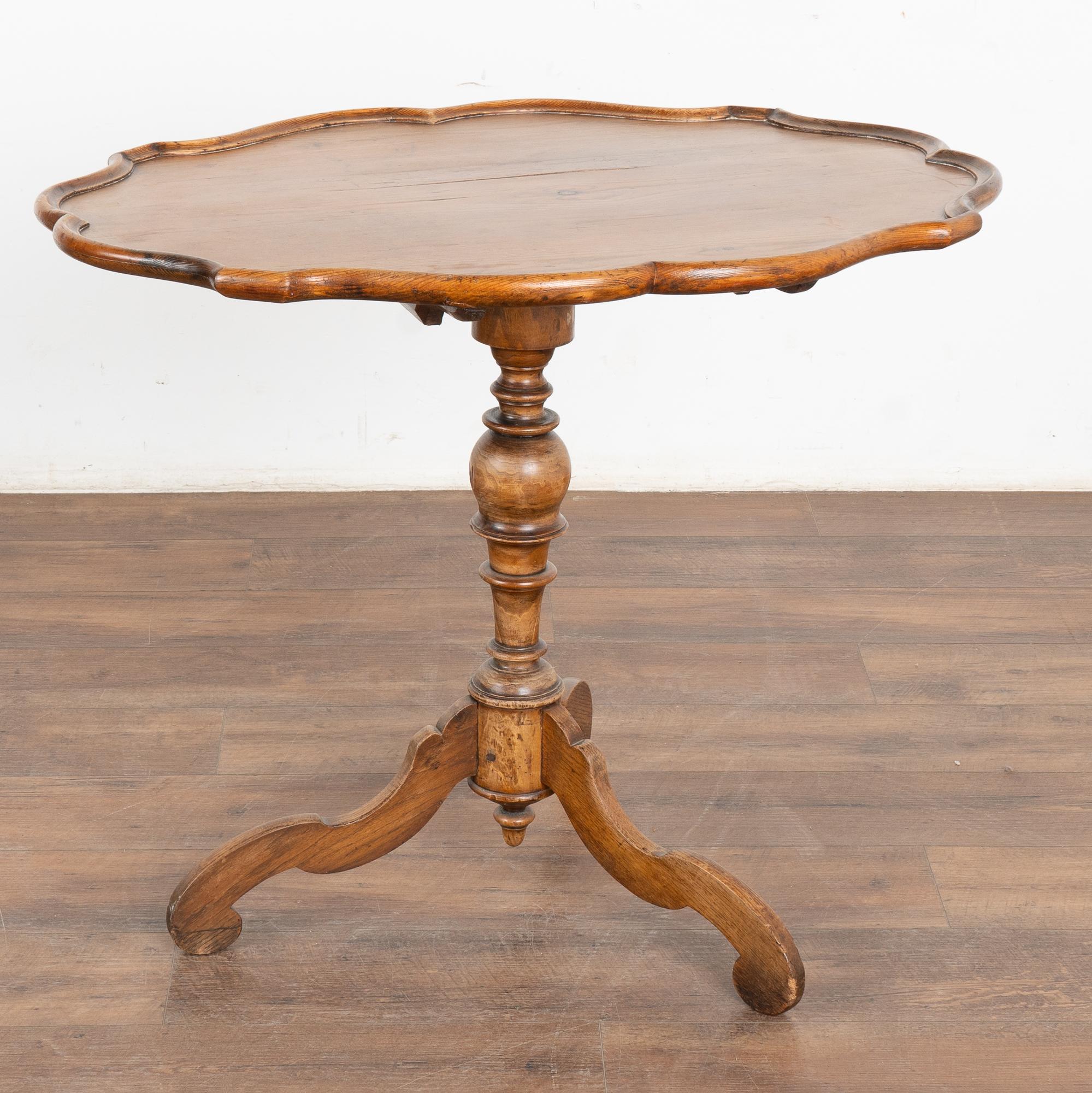 The aged warm patina of the pine top attracts one to this tilt top table, originally often used as a tea table in Sweden.
Sits stable on turned pedestal tri foot base.
Height with top tilted: 48.5