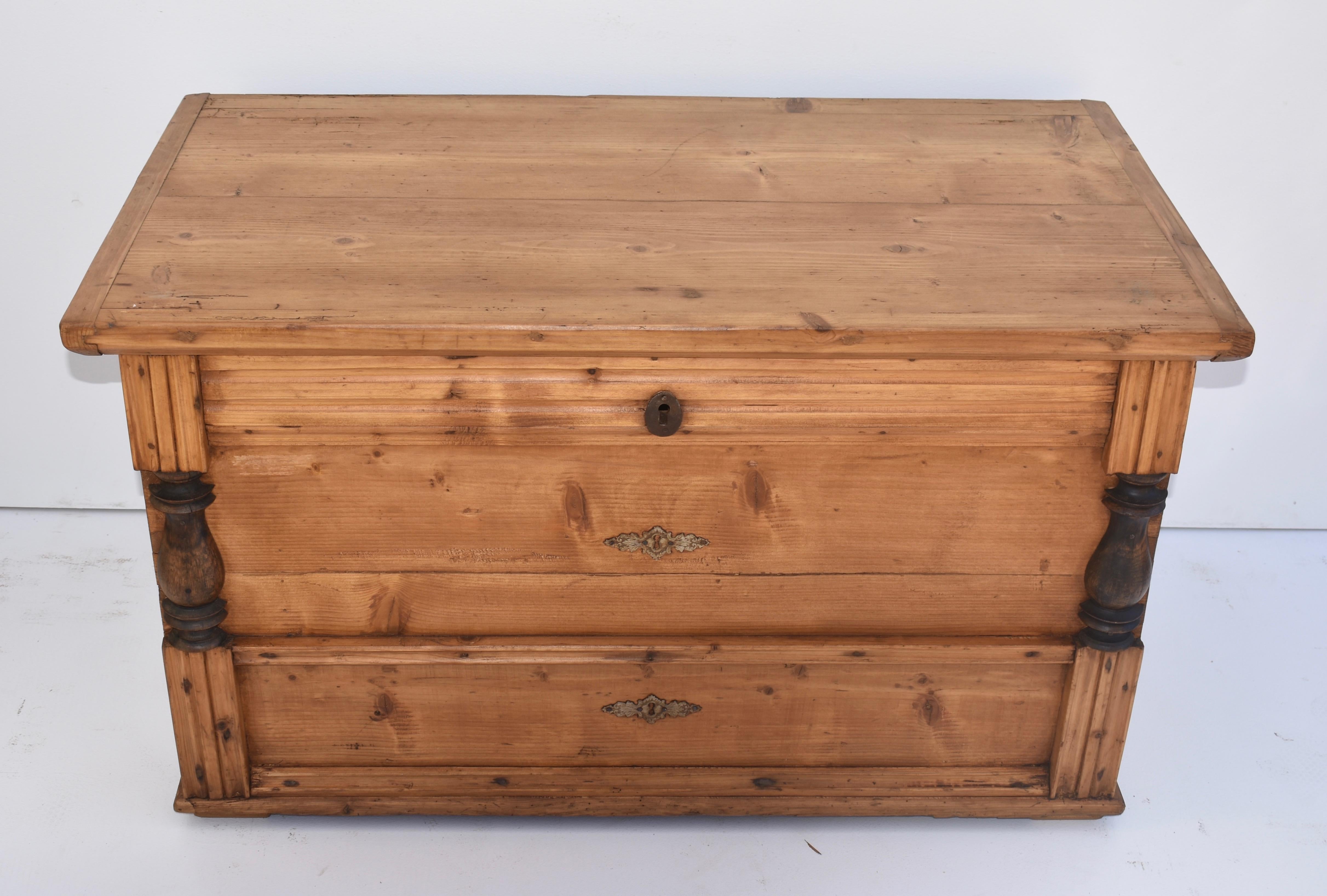 This beautiful faux mule chest wants to suggest it has drawers but the front is just paneled that way. The “drawers” are flanked by ebonized split columns, with boldly fluted bases and capitals. The top lifts to a deep storage well inside with a