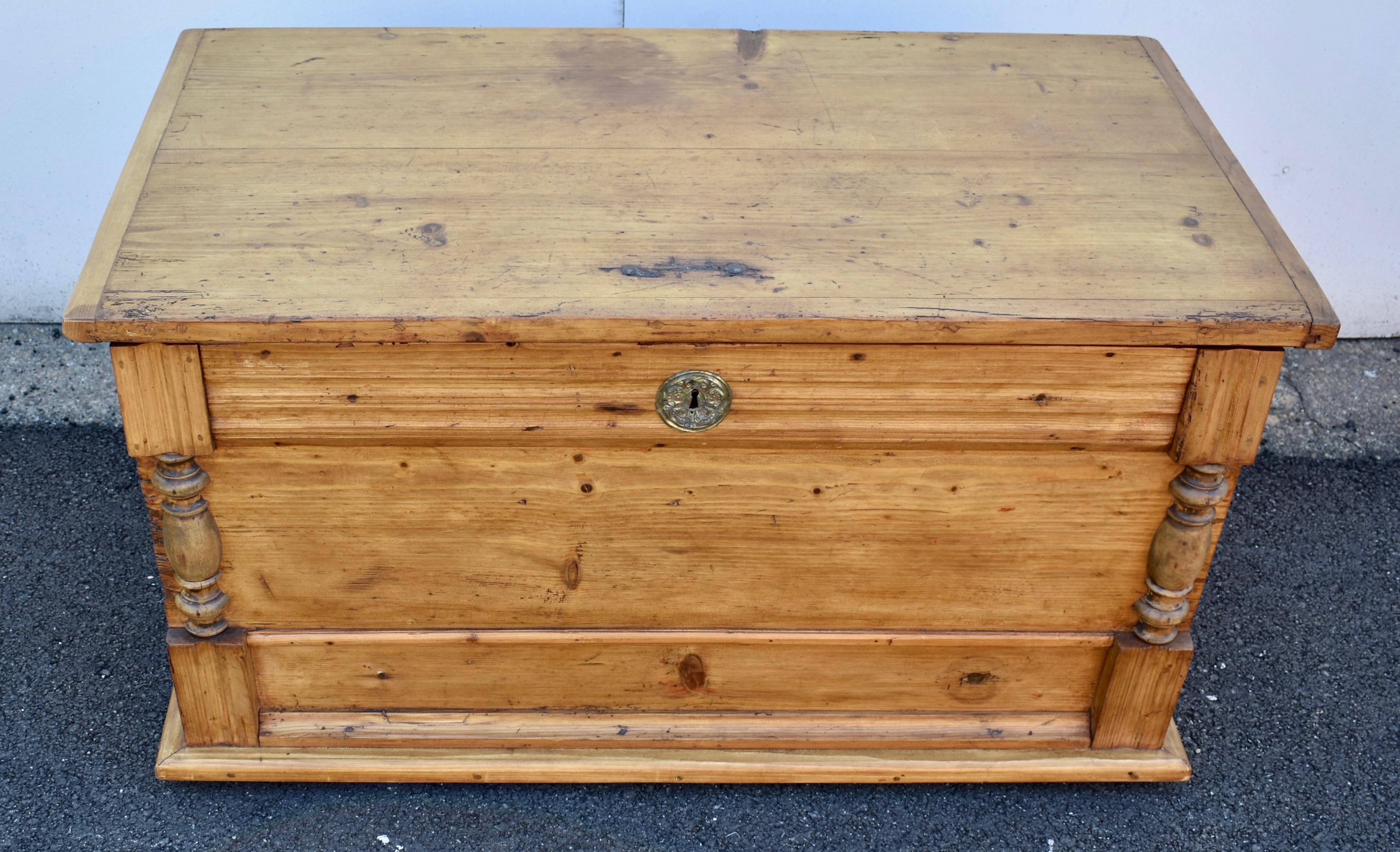 This deep and rather stately trunk is a “faux” mule chest. The front is divided into three lateral sections. The top section, with three rows of reeding and a pressed brass escutcheon plate, and the bottom,. both had knobs that disguised them as