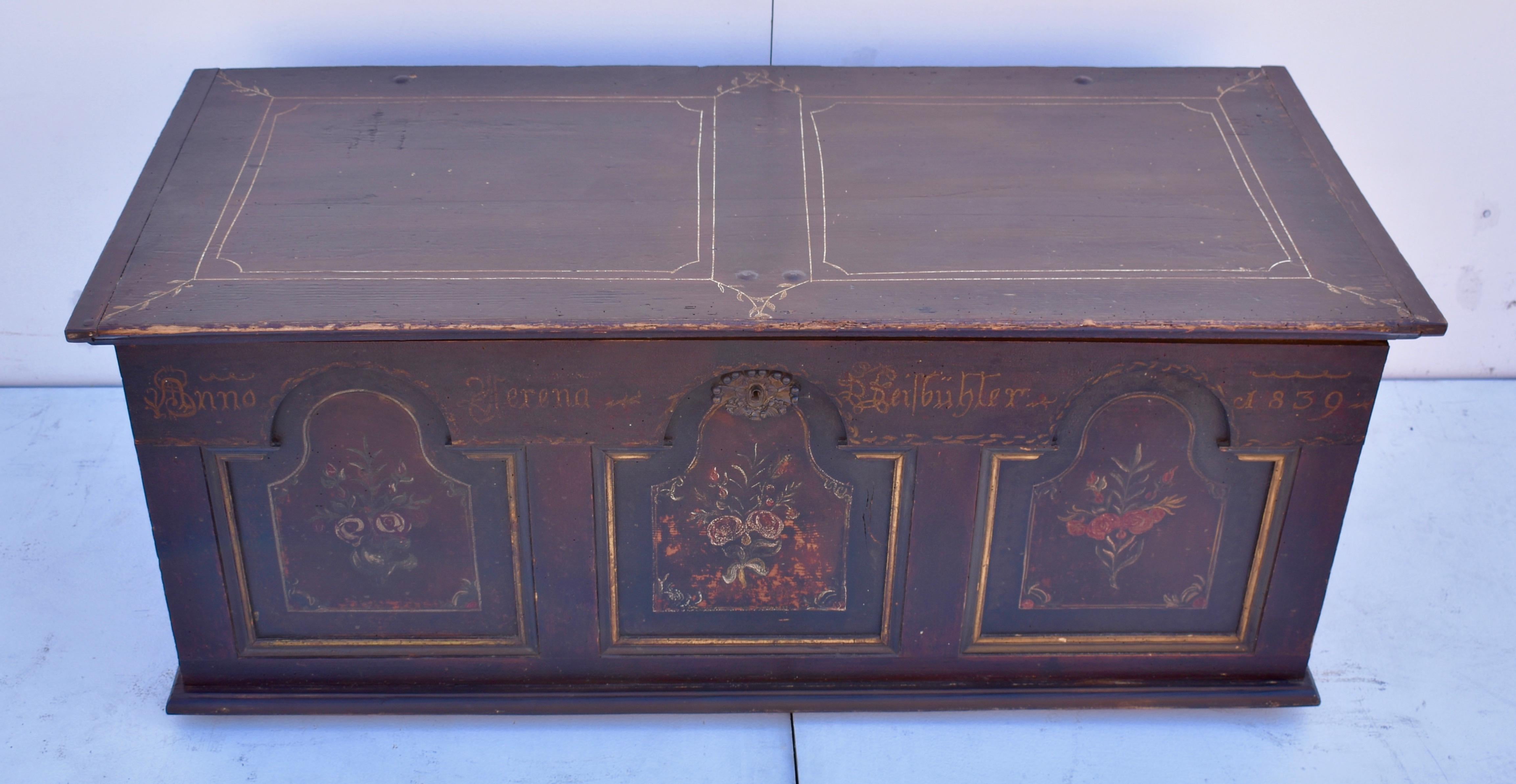 What an outstanding blanket chest! Its painted background is a barn red on which an old varnish has bubbled, crackled and separated to create a beautiful speckled surface. The top and sides have horizontal waves of red and near-black with linear