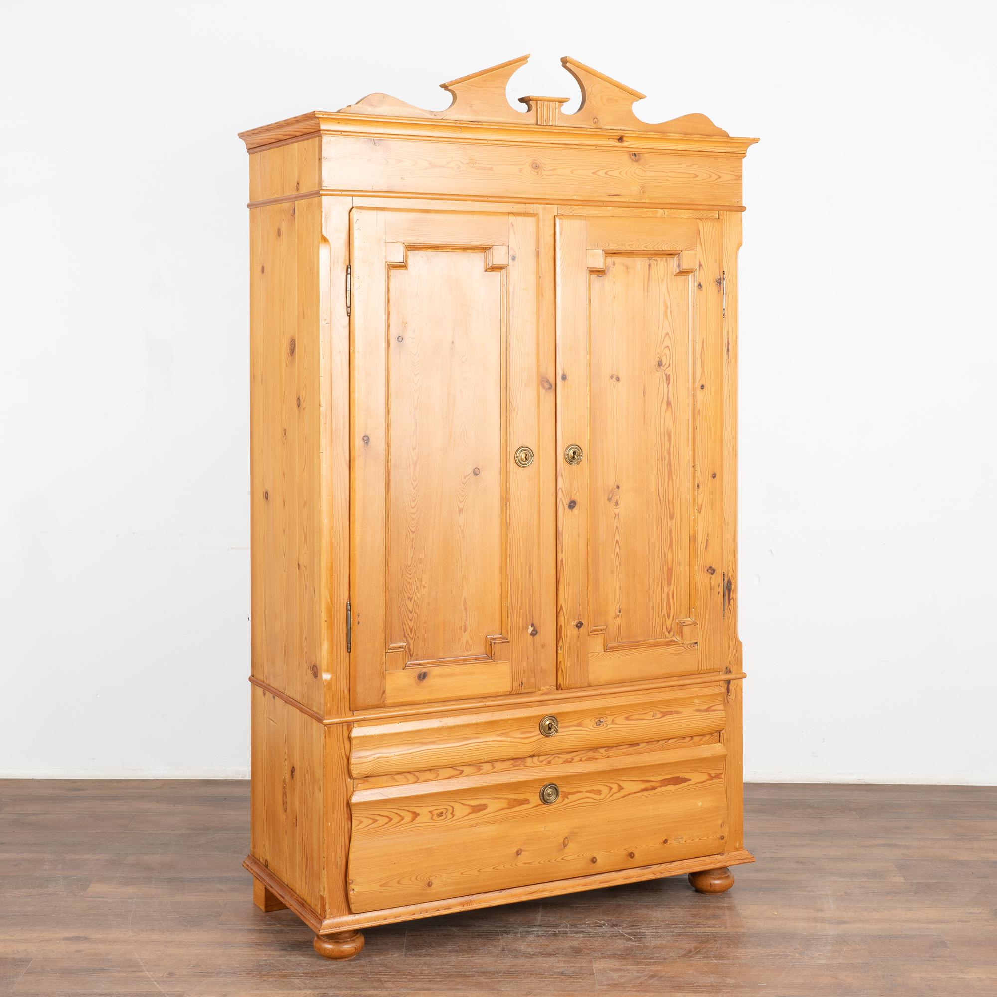 It is the captivating patina of the warm pine that captures one's attention in this lovely armoire.
Note the two lower drawers and red painted interior. Upper decorative crown is easy removed for shipping and if client desires a more simple overall