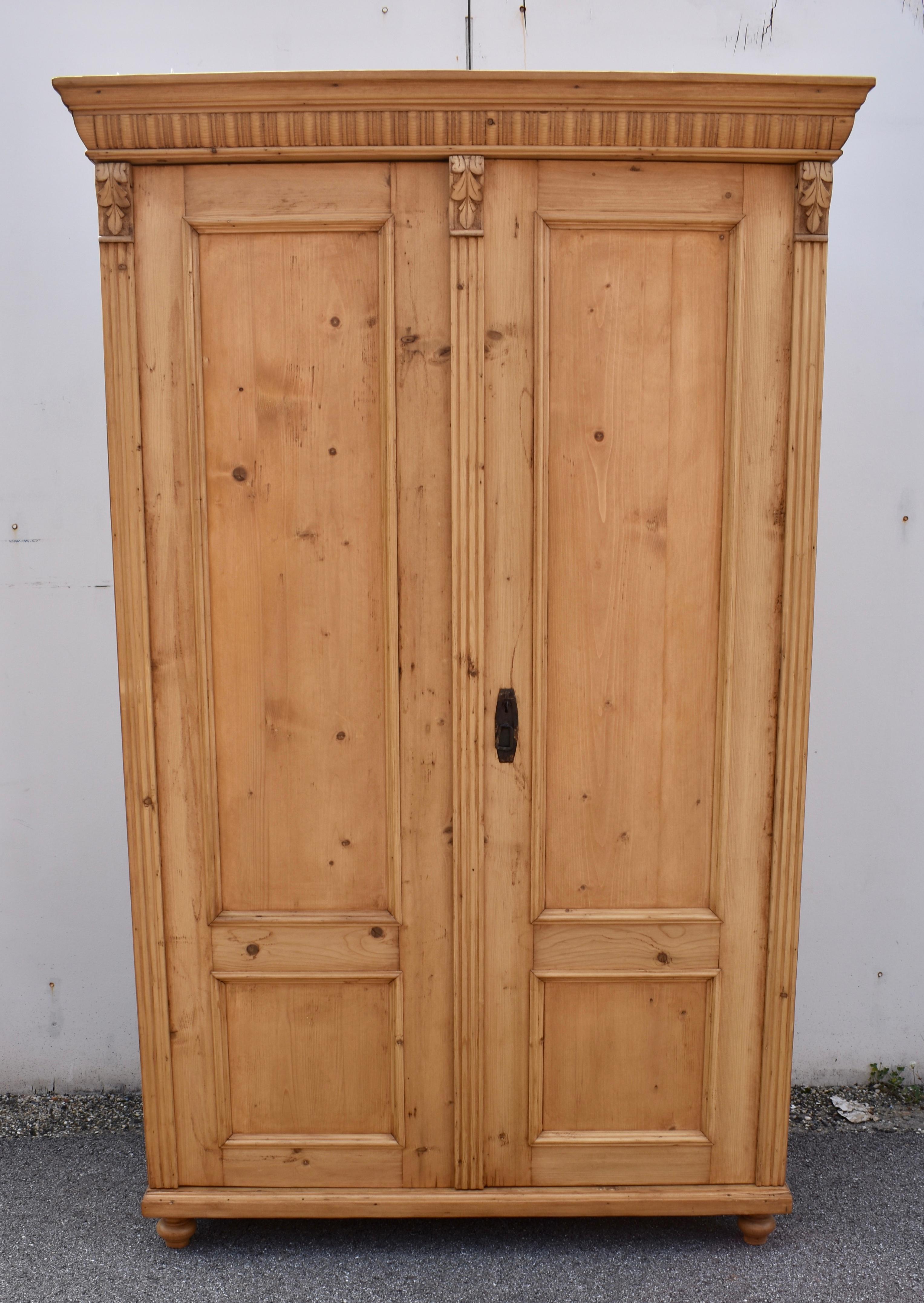 Este precioso armario de dos puertas tiene un color precioso y un encanto considerable.  La corona es atrevida, con una bonita moldura conopial sobre una hilera de gallones.  Las puertas tienen cada una un panel plano largo y otro corto, y están